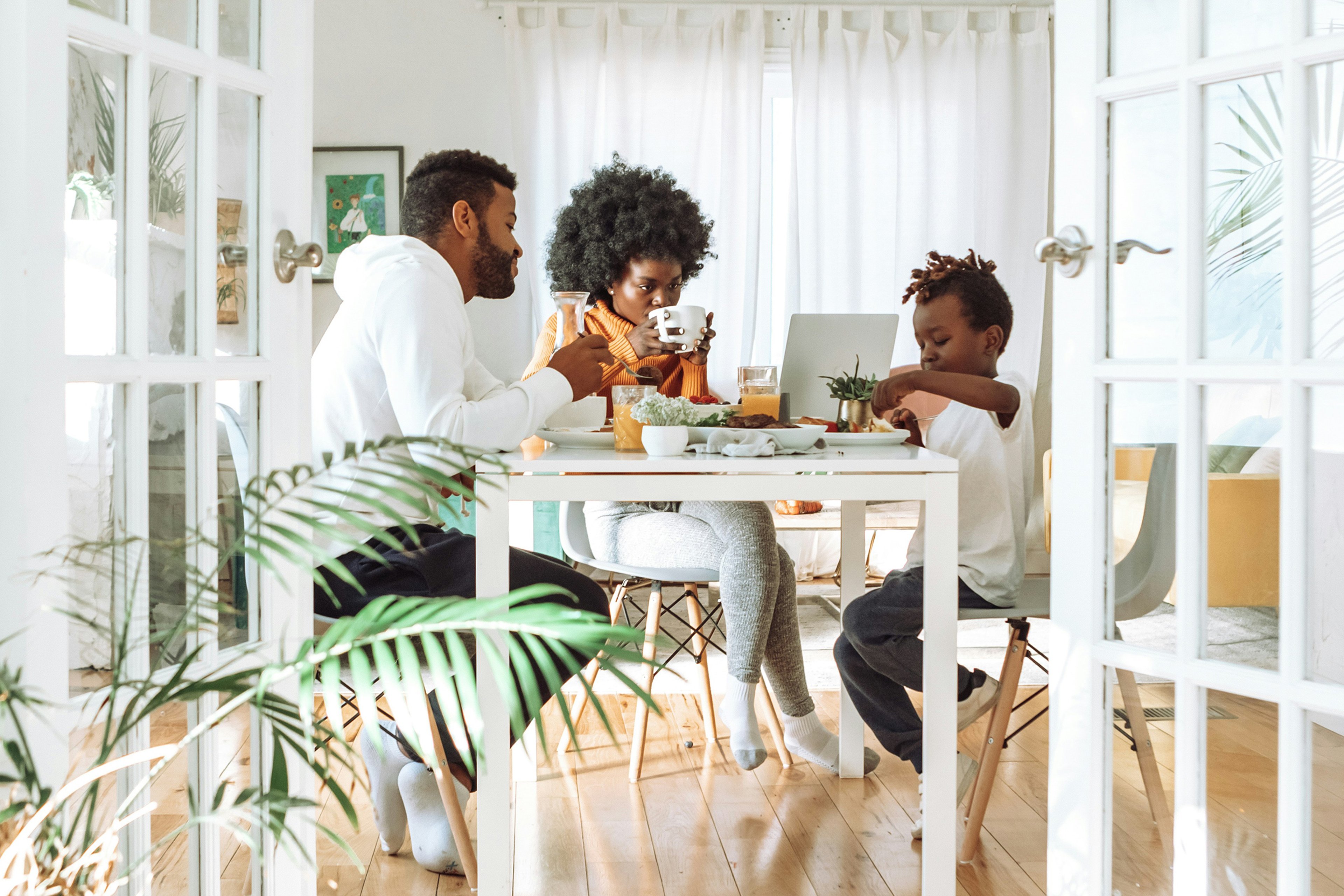Family of three sitting at table enjoying breakfast