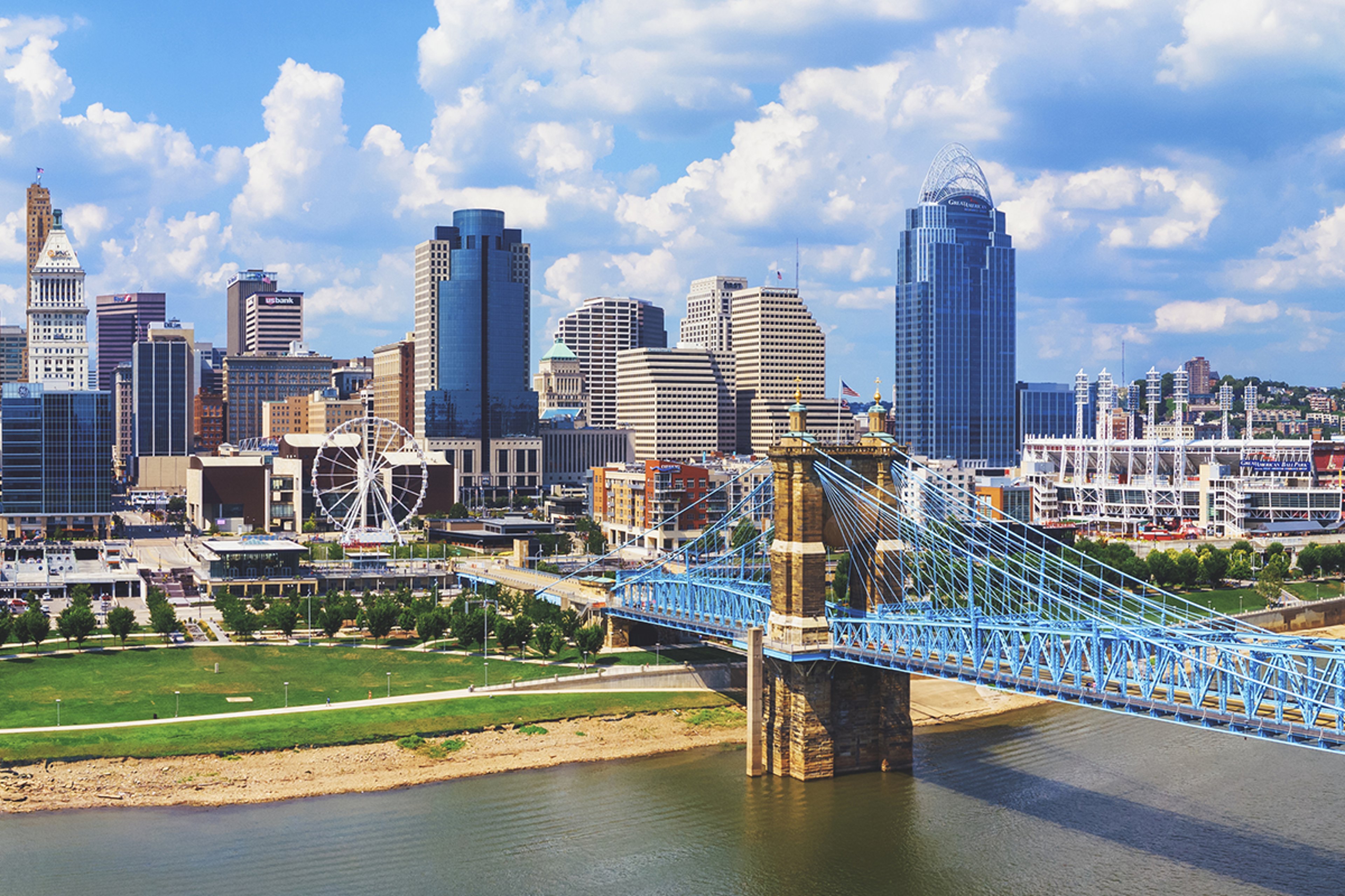 City skyline beside a river under a clear blue sky