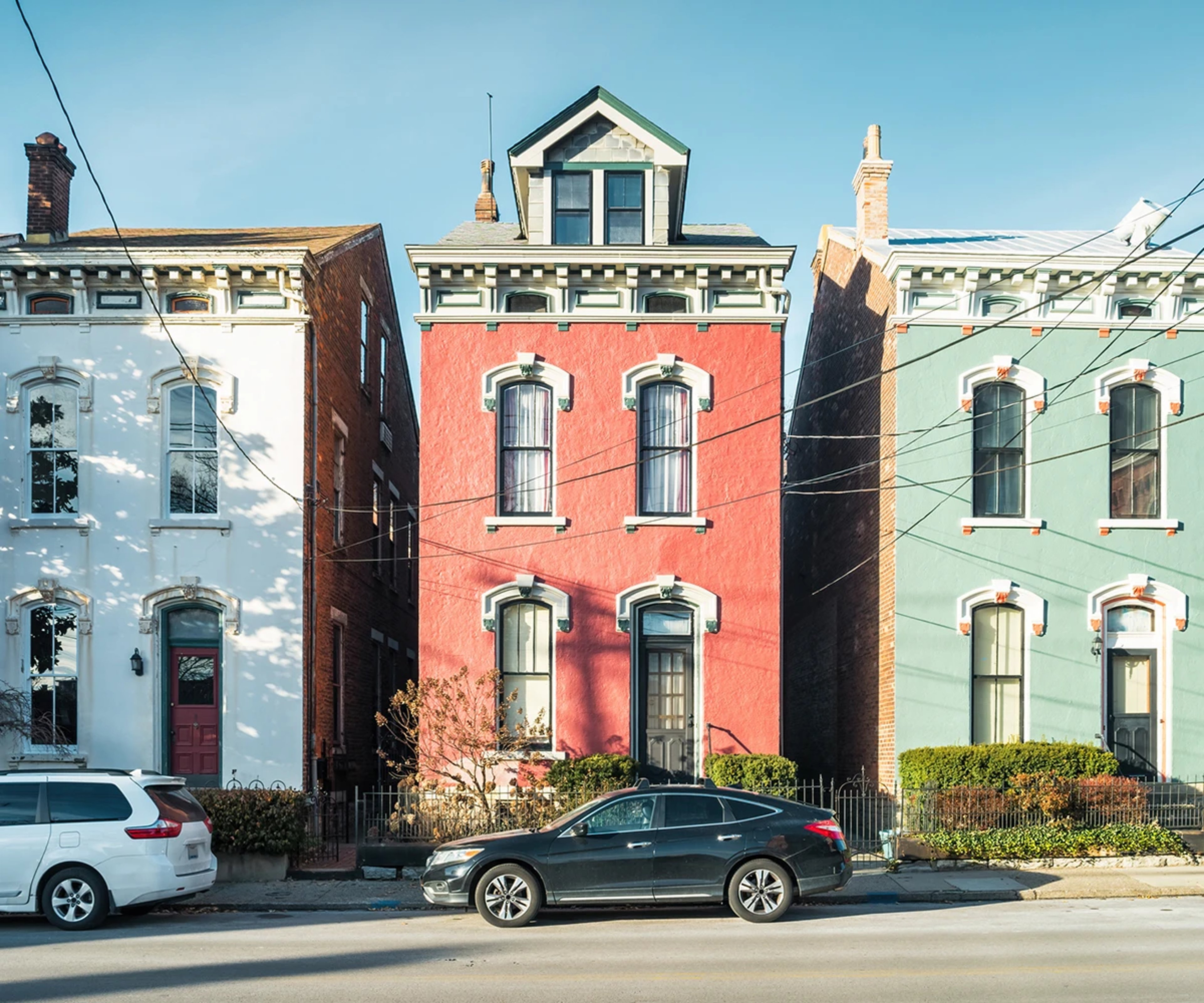 Black car parked in front of colorful Cincinnati house