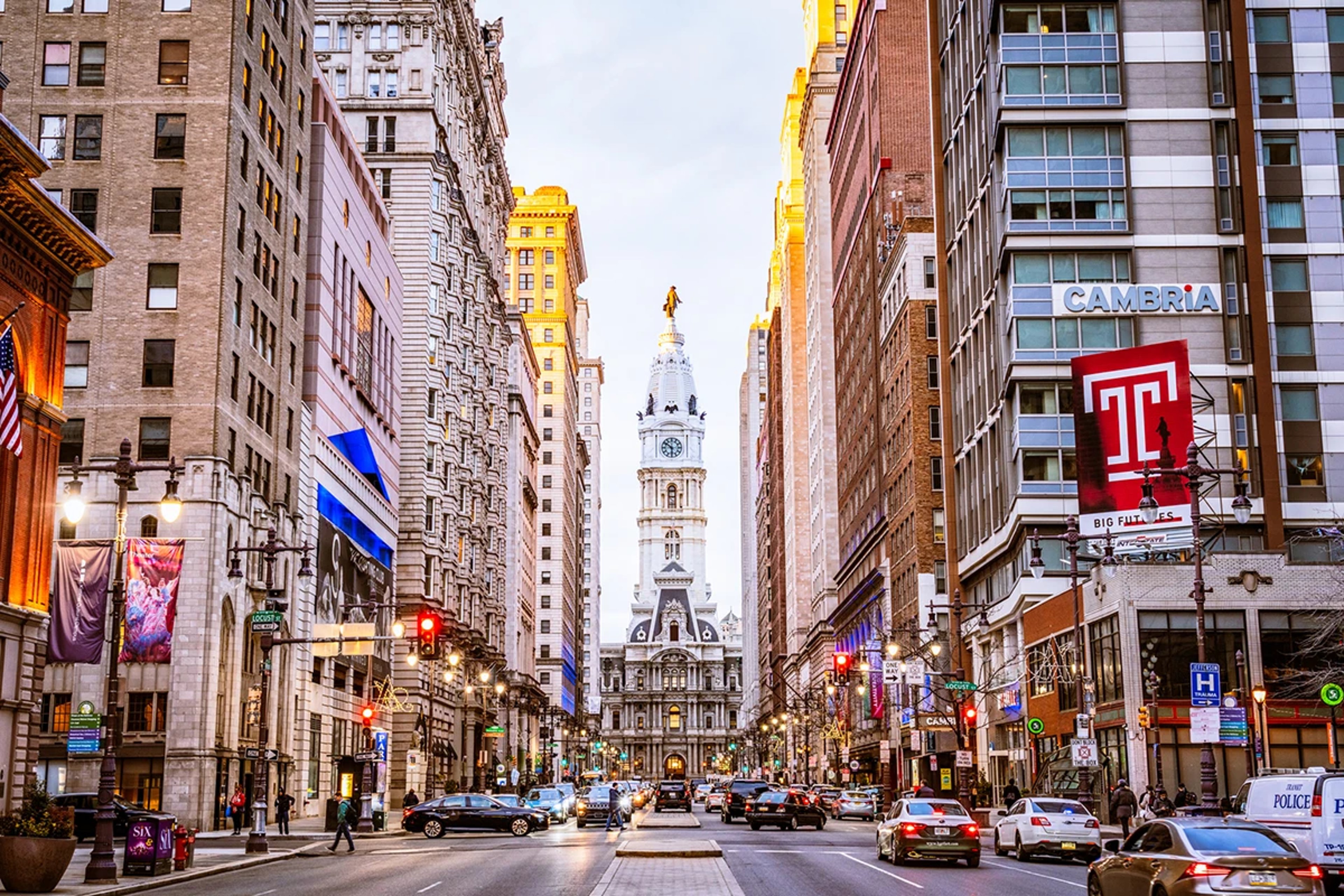Cars driving on streets with Philadelphia City Hall in the background