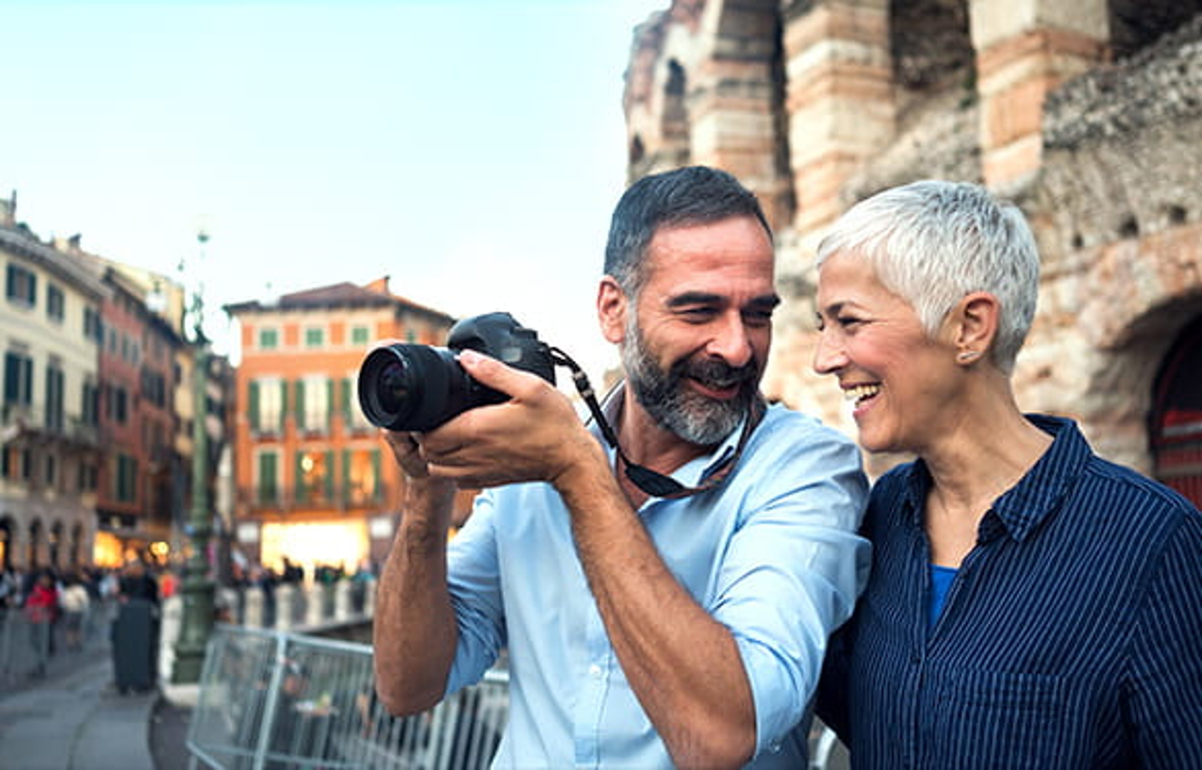 Senior couple smiling and taking pictures on vacation