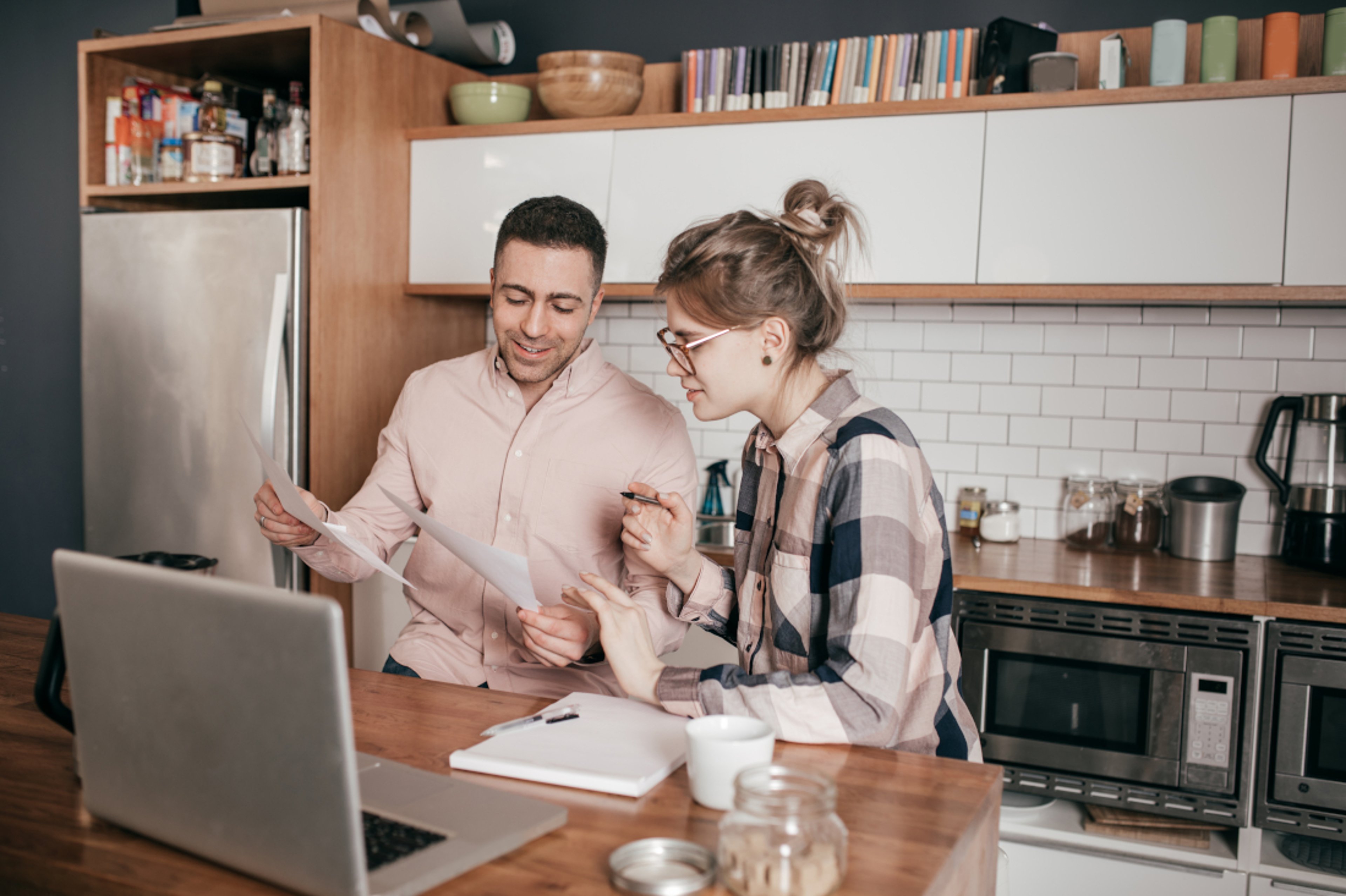 Couple standing by kitchen counter in their apartment 