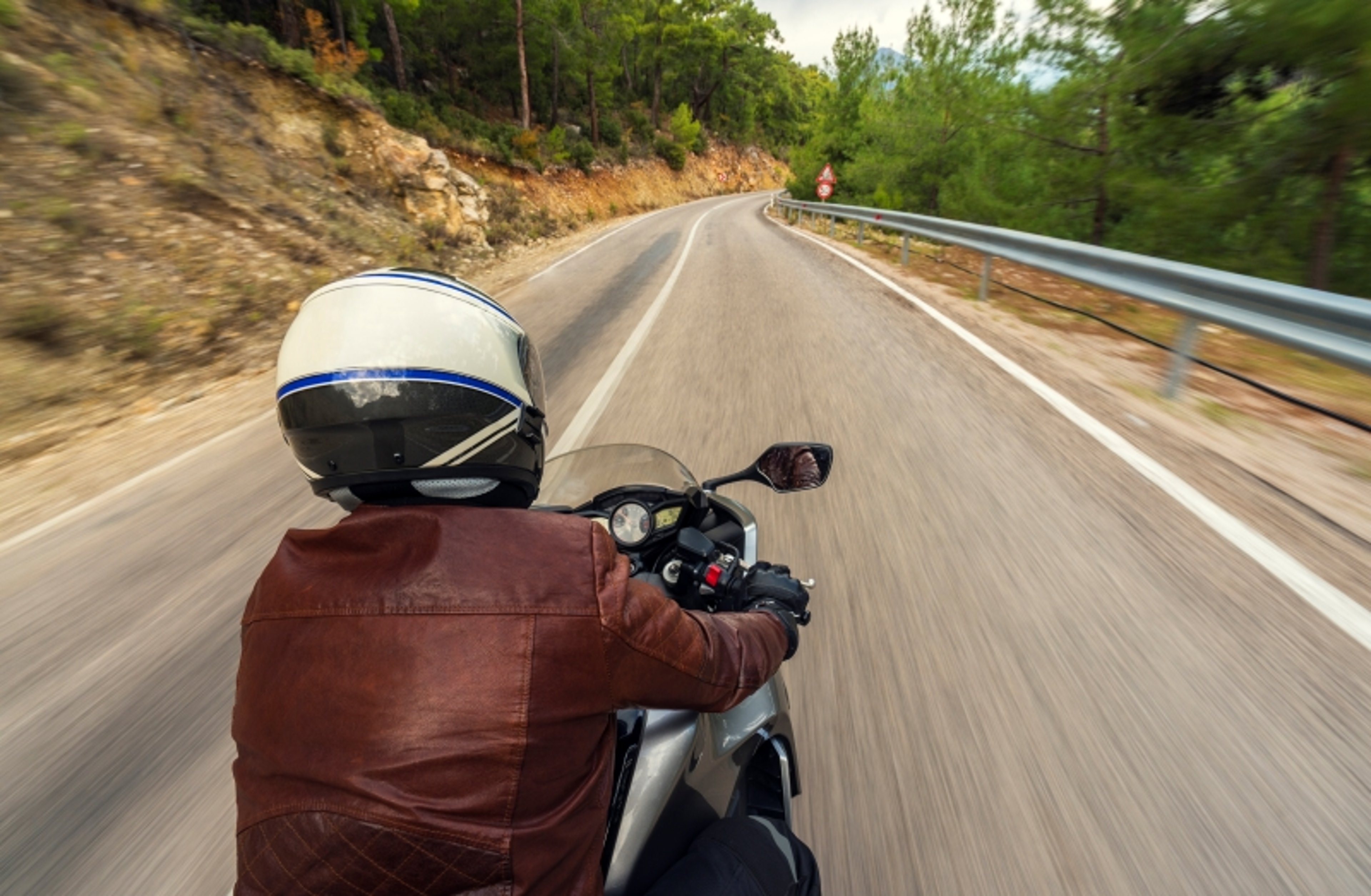 Mototcycle driver with helmet and brown leather jacket 