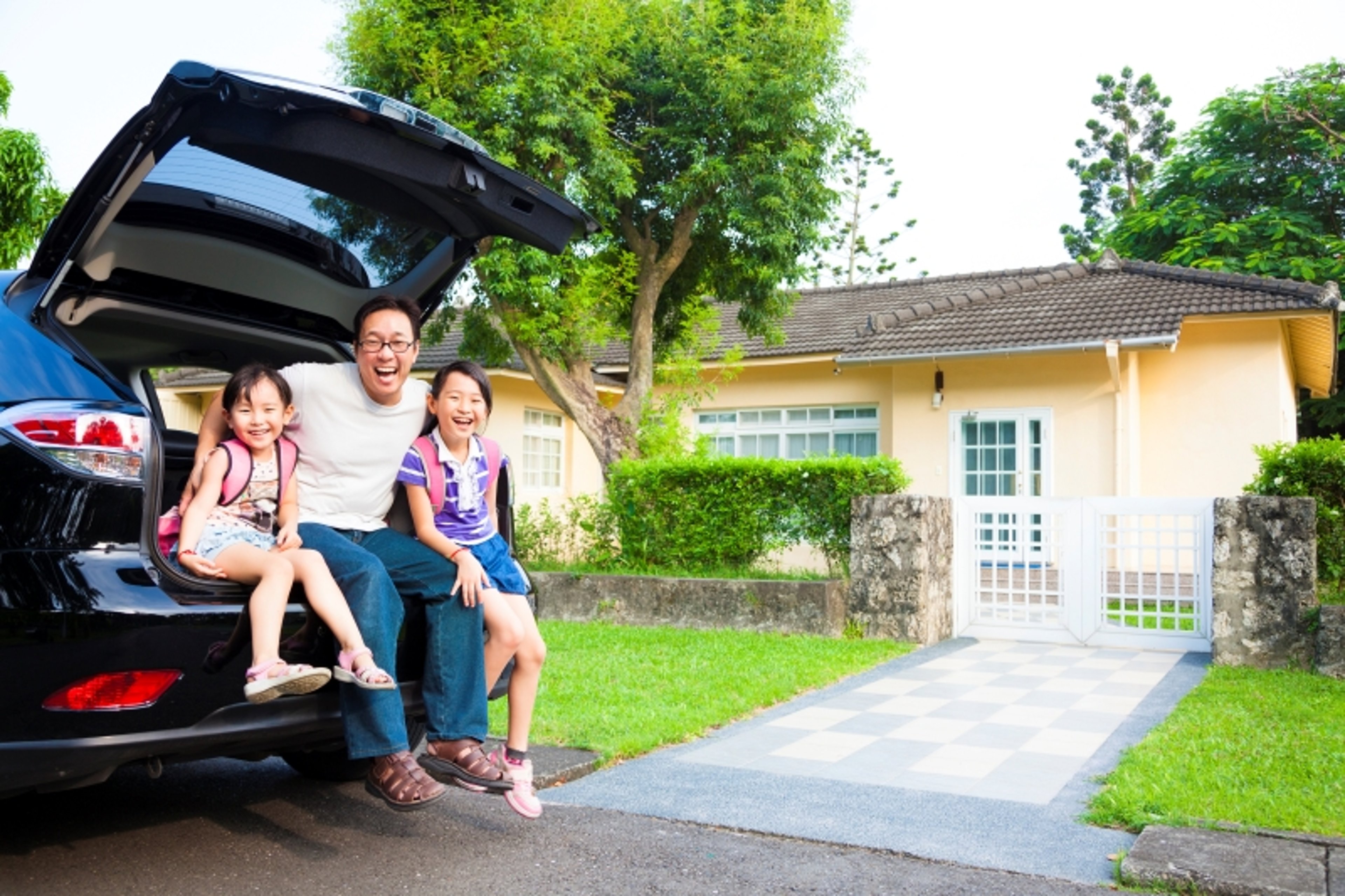 Family smiling sitting in car trunk