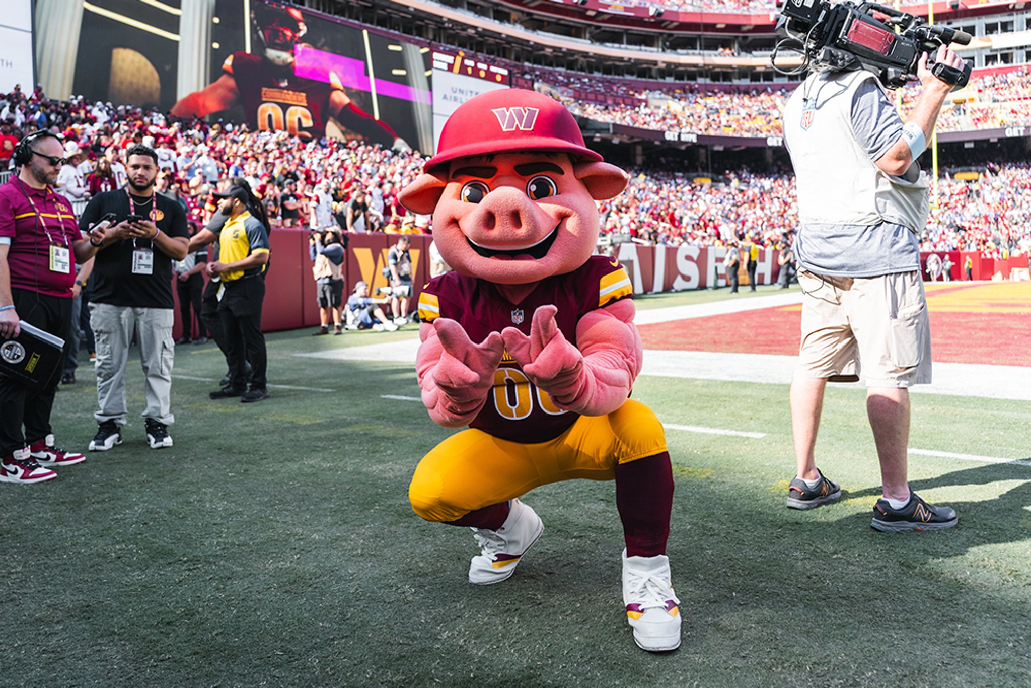 Washington Commanders mascot holding up W sign with its hands on the sidelines