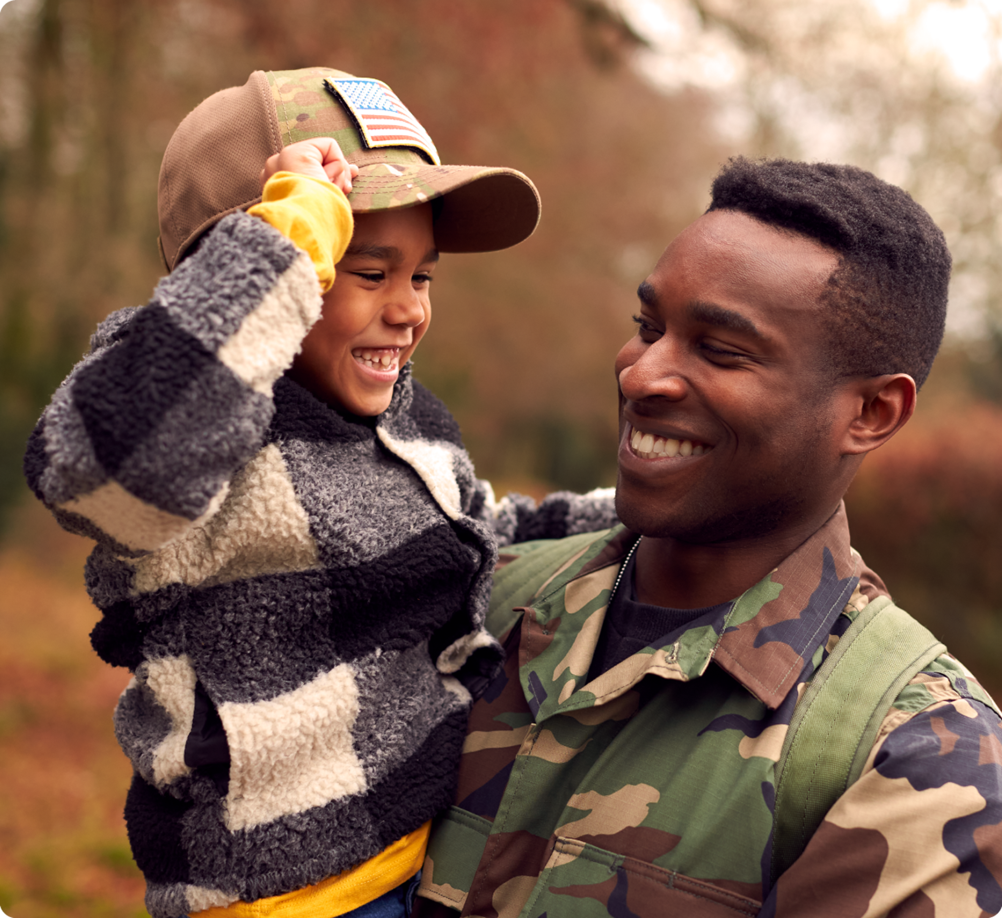 Smiling serviceman carrying his child on his shoulders