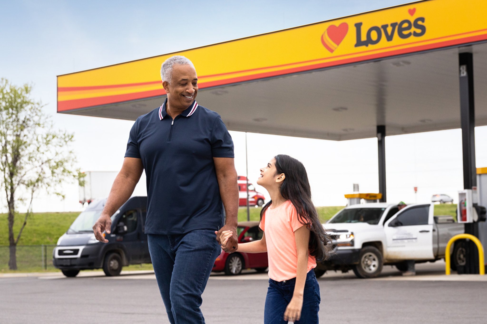 Man and girl walking in front of Love’s gas station.