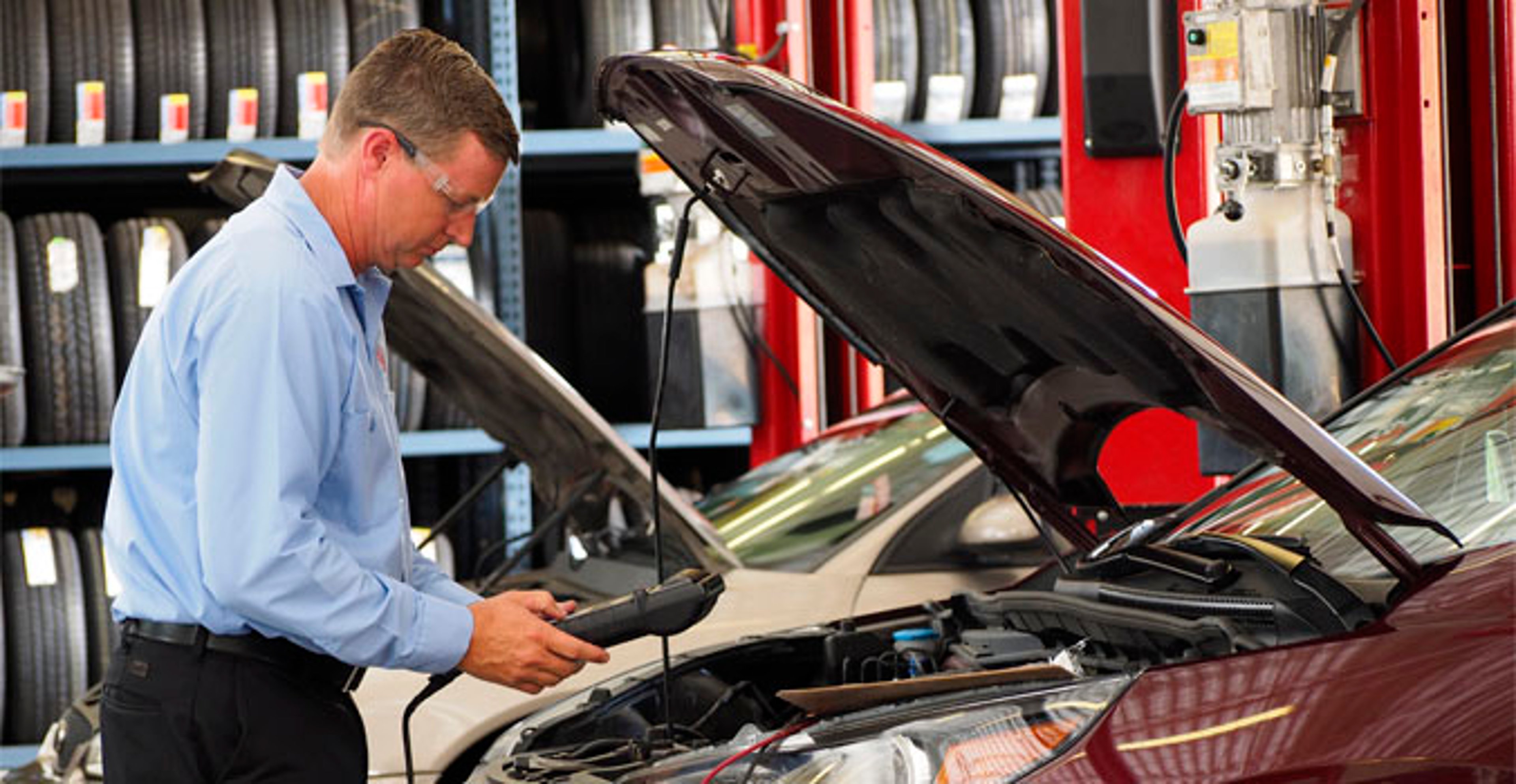 AAA agent looking underneath the hood of a car