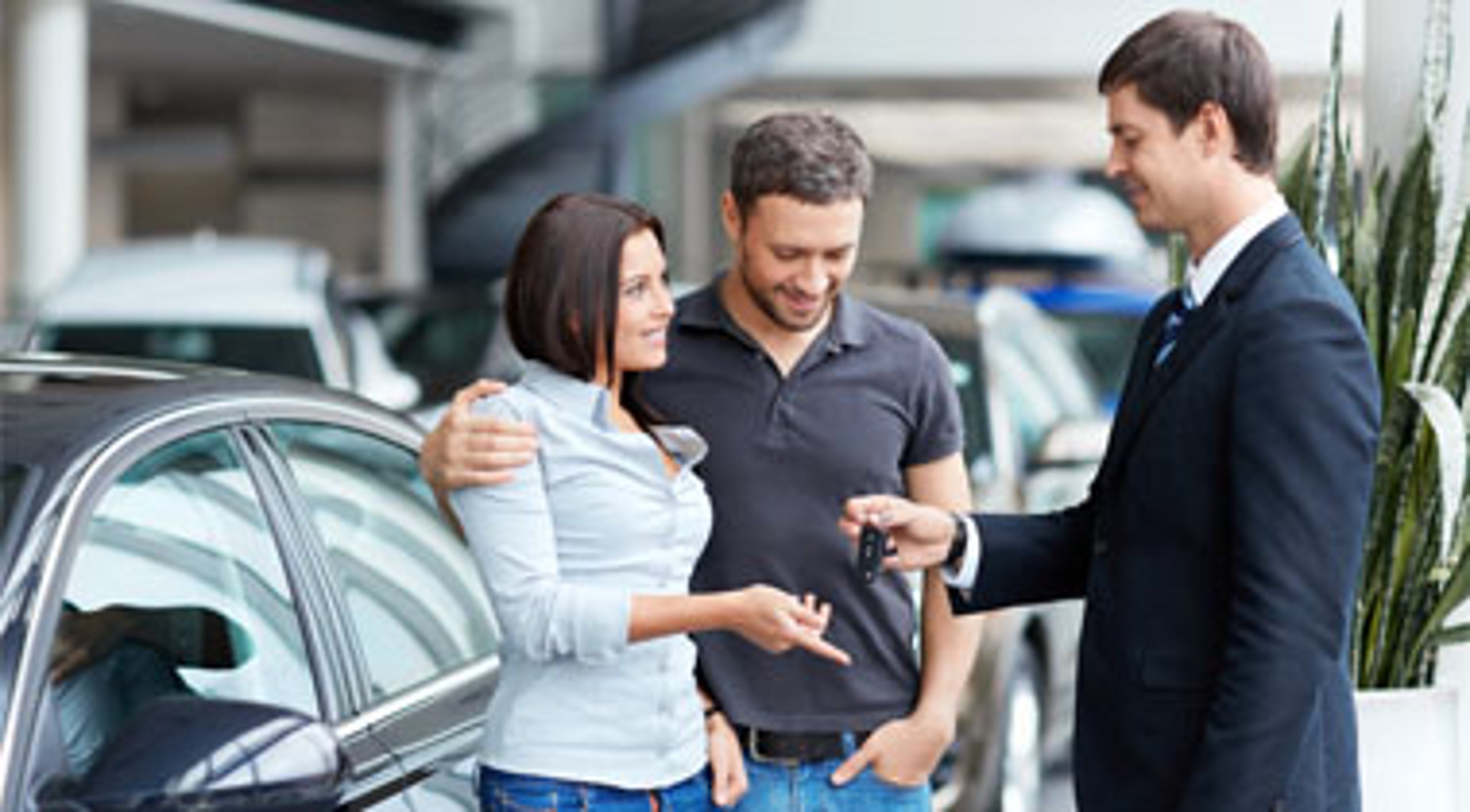 Man hands car keys to a couple