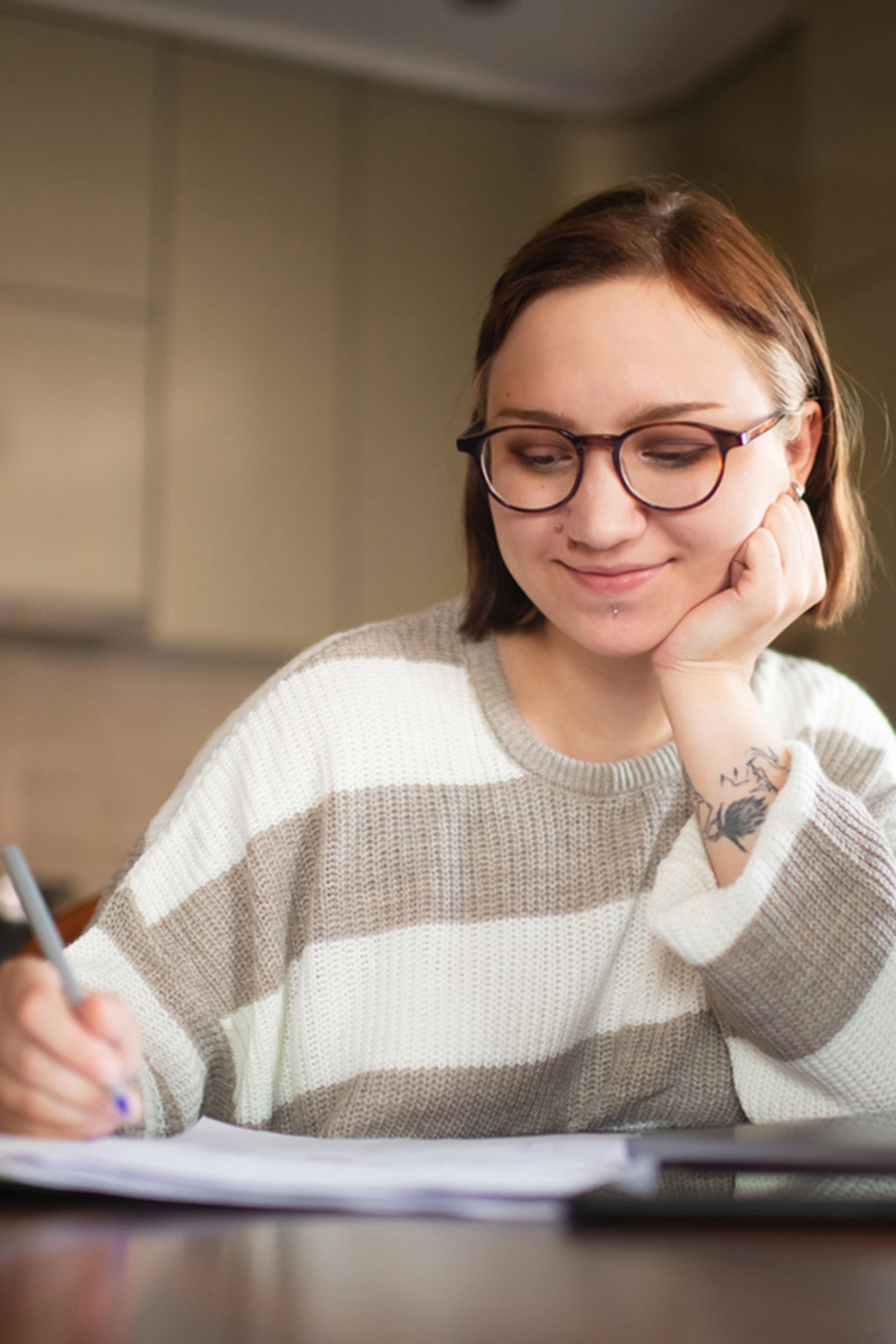 Girl writing on paper and researching student loan repayments