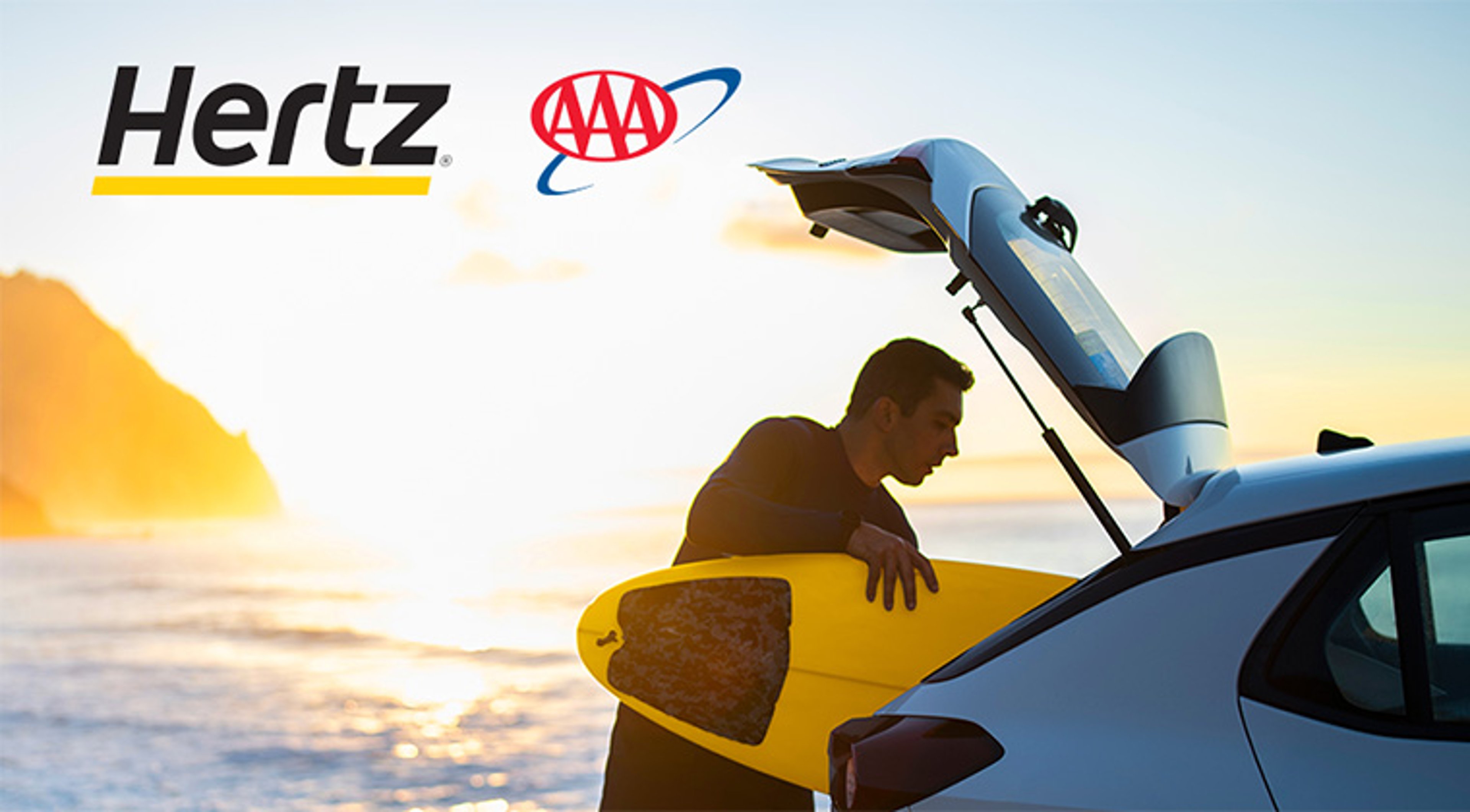 Man loading surf board into the back of a hatchback car at the beach