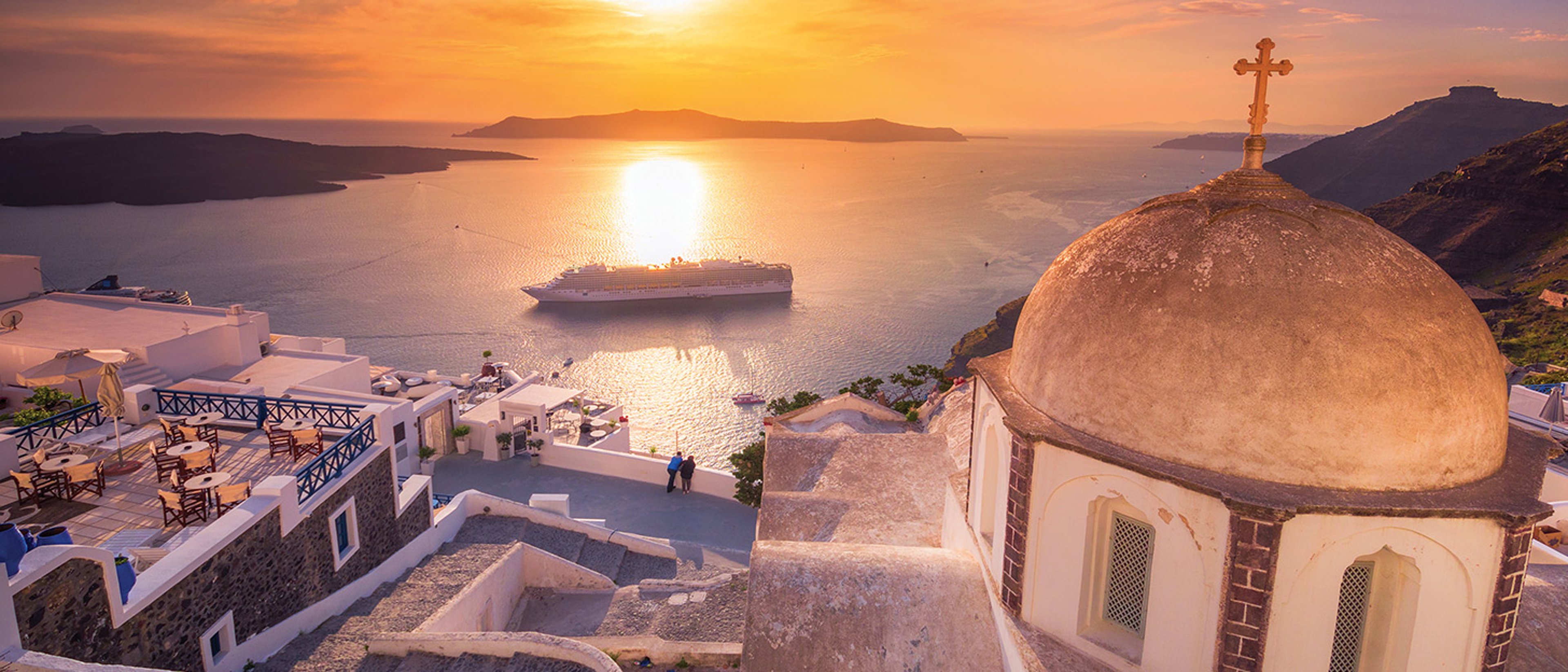 The image appears to show a scenic sunset view over the caldera in Fira, Santorini, Greece, featuring a domed church and a cruise ship in the water.