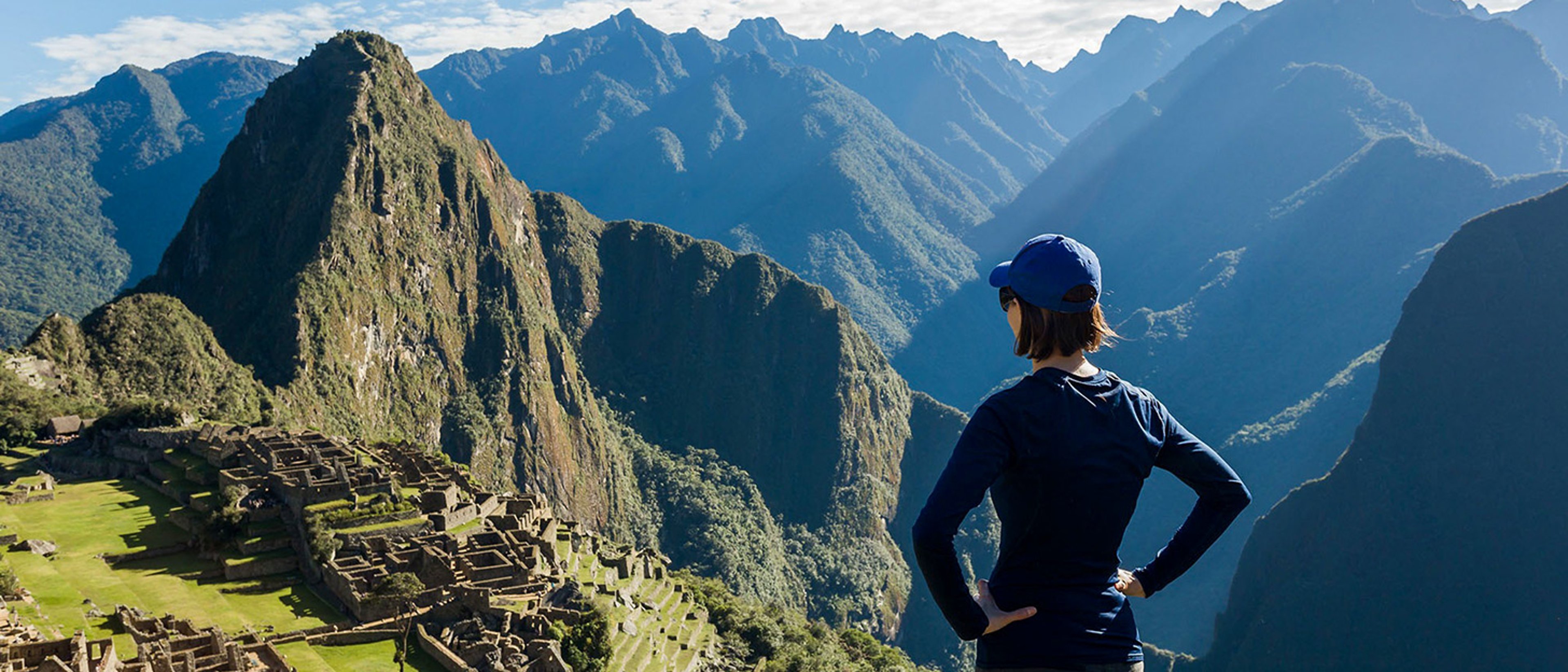 Solo female traveler overlooking the ruins of Machu Picchu in Peru