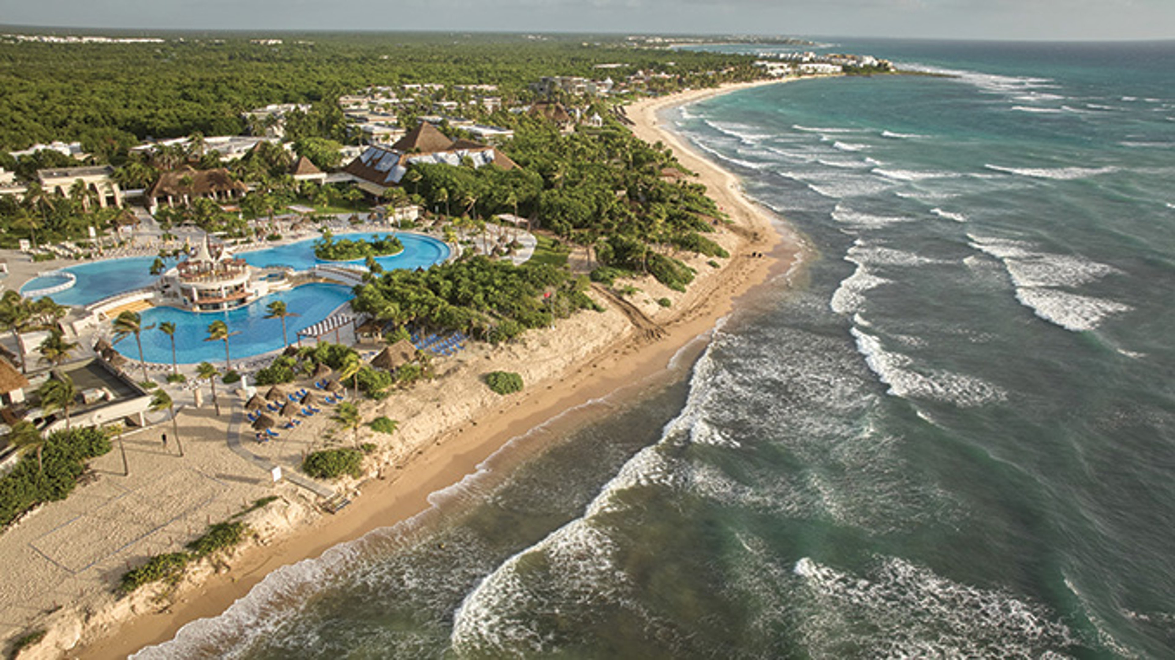 Aerial view of pool and palm trees at Hotel Bahia Principe Grand Tulum, Mexico