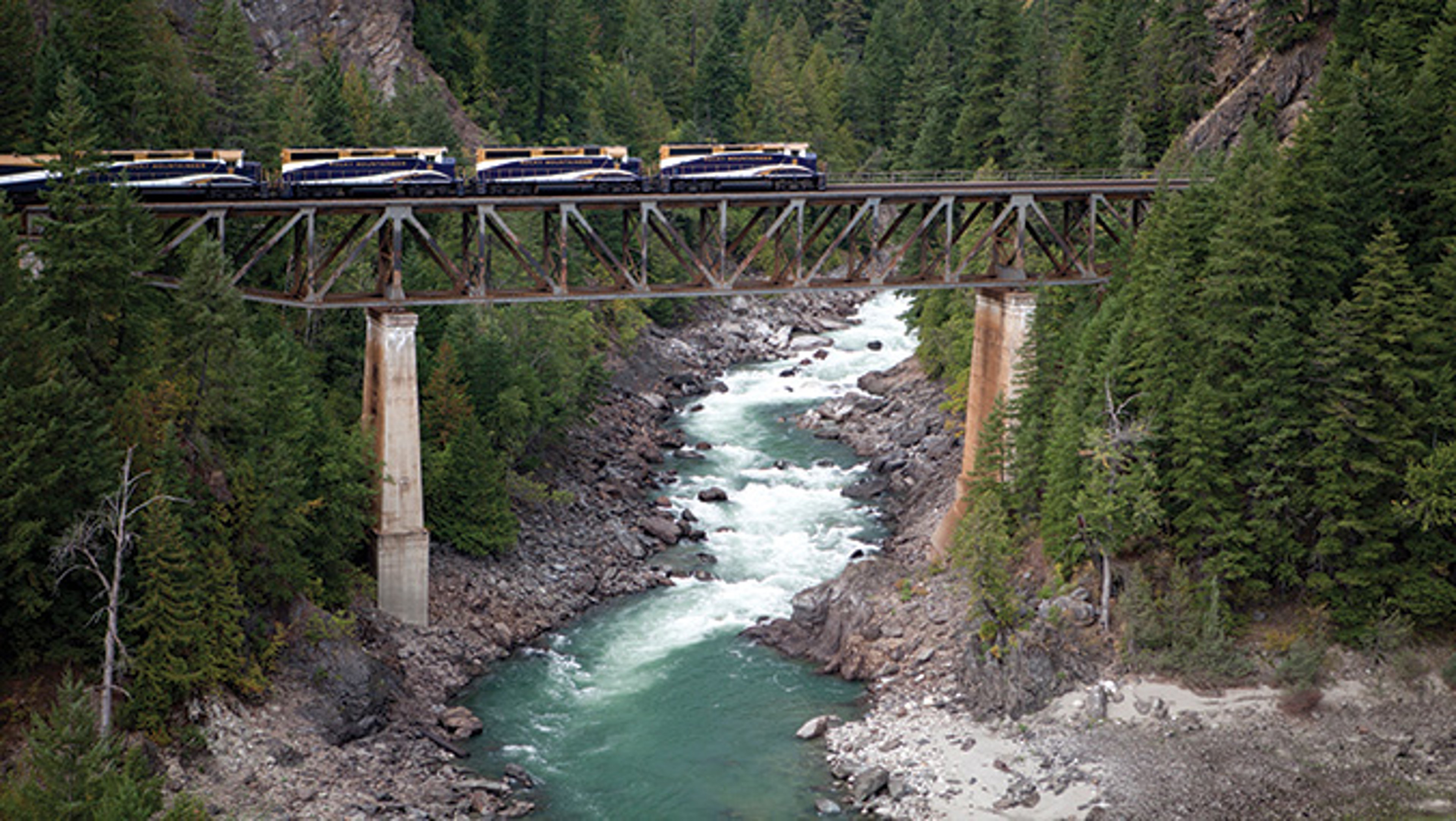 Rocky Mountaineer train on the suspension bridge above blue waters by Whistler Mountain, British Columbia, Canada