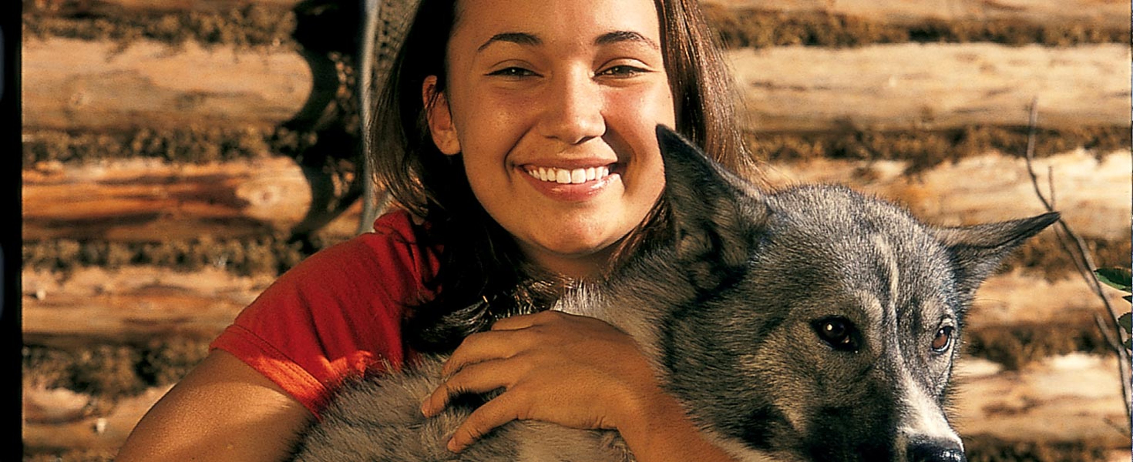 Young woman holding an Alaskan sled dog