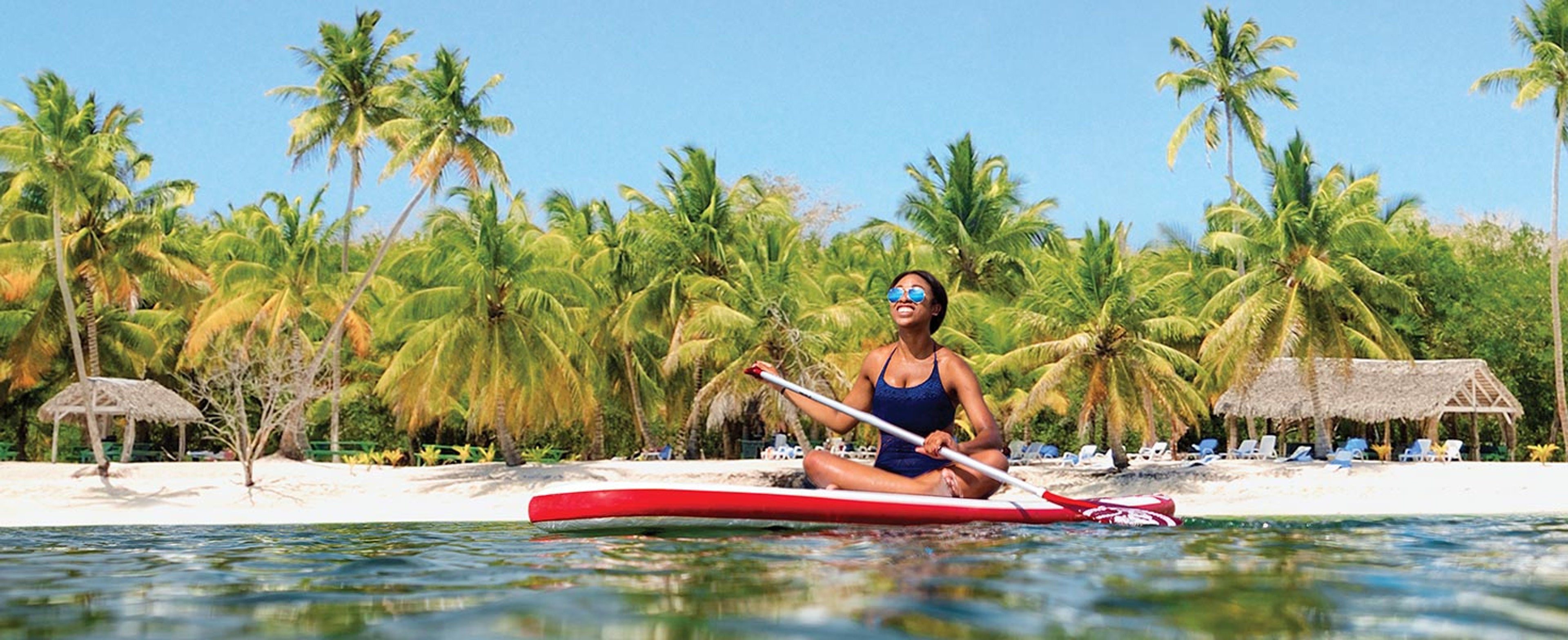 woman riding paddle board along coast of St Maarten