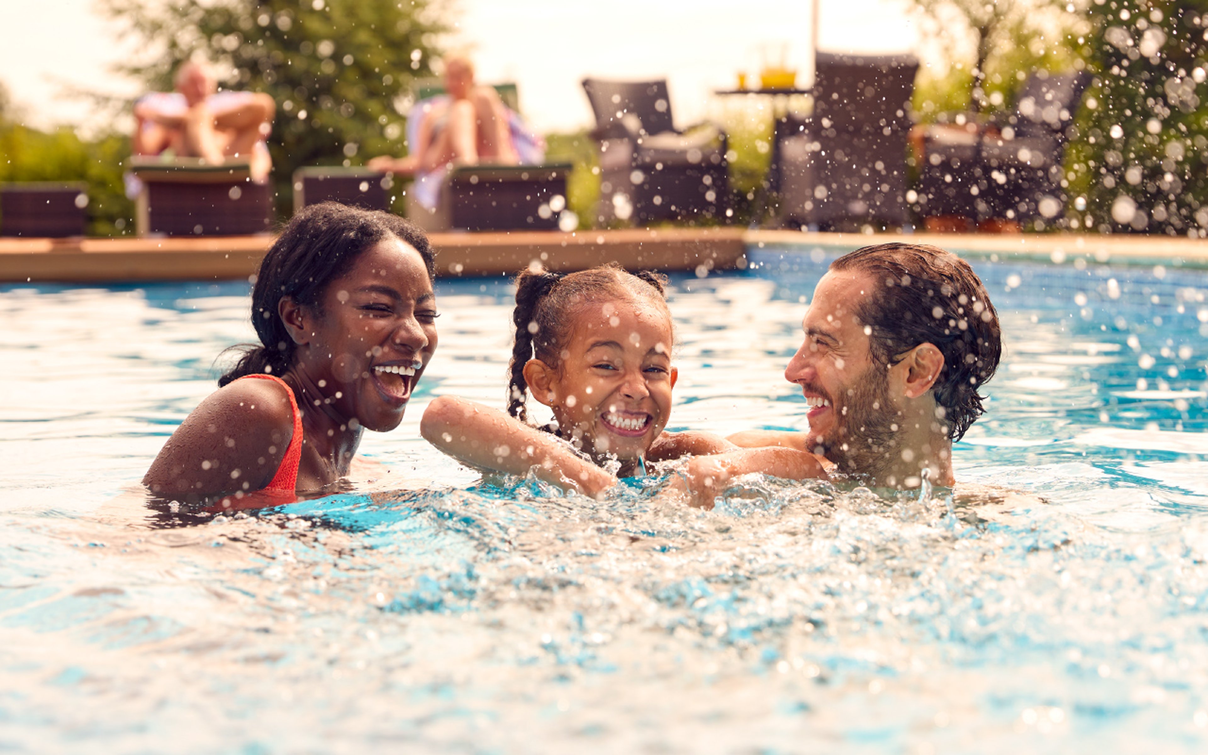 Diverse family having fun at a pool on vacation 