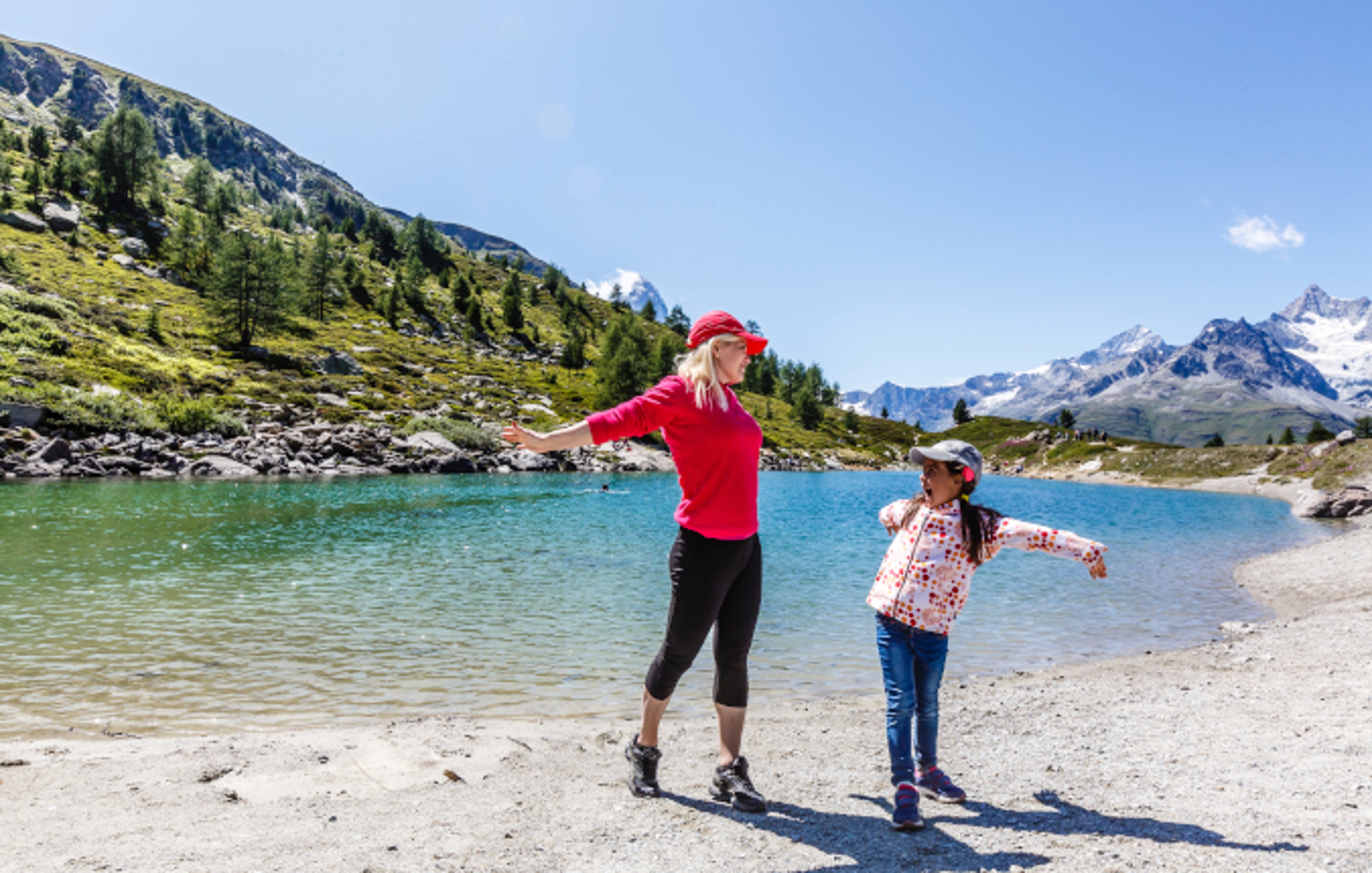 Woman and daughter having fun on the shore of Alaskan lake