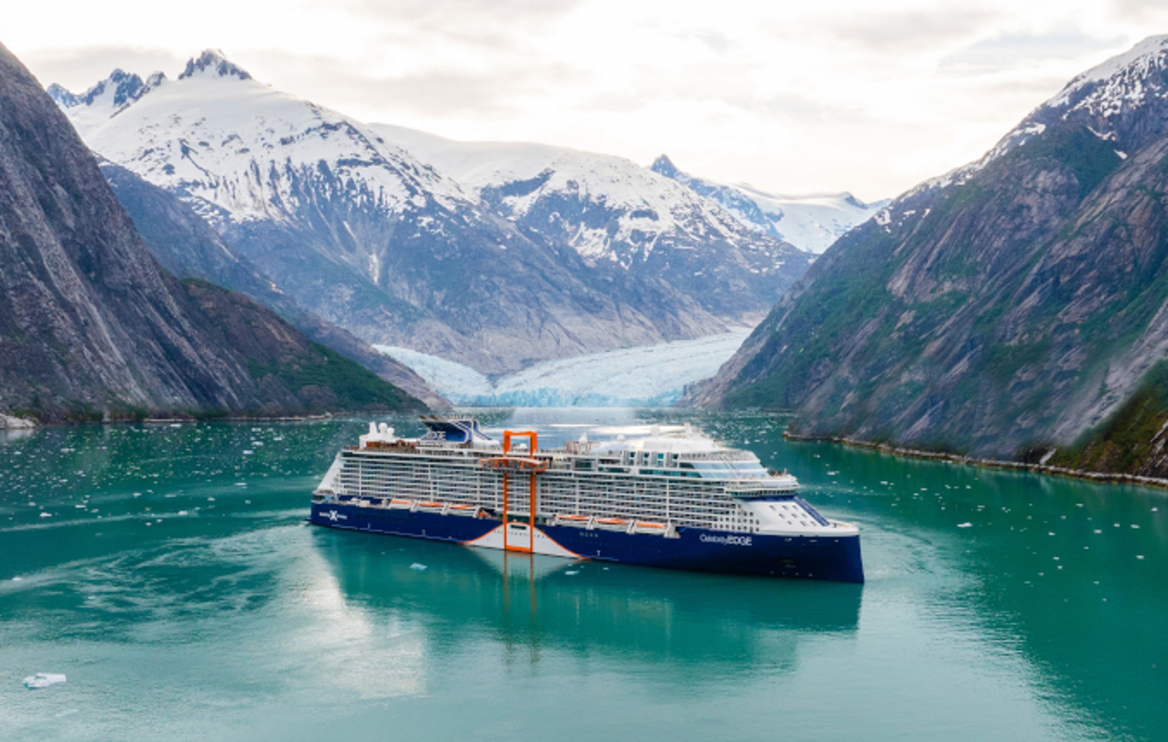 Celebrity cruise ship in a glacial lake between two mountains