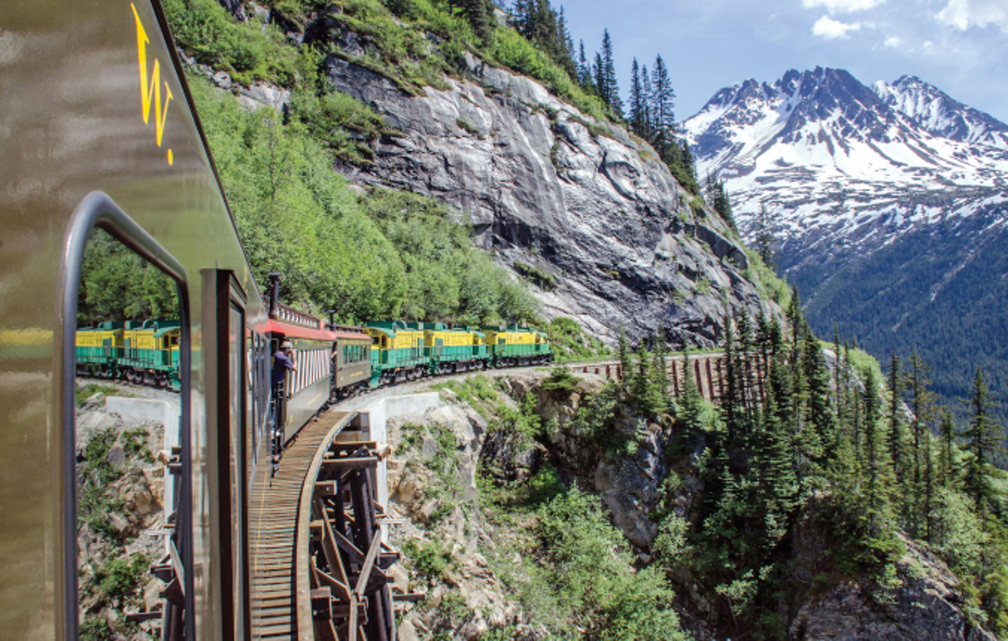 White Pass & Yukon Route Railroad travels along the cliffs heading towards Skagway, Alaska