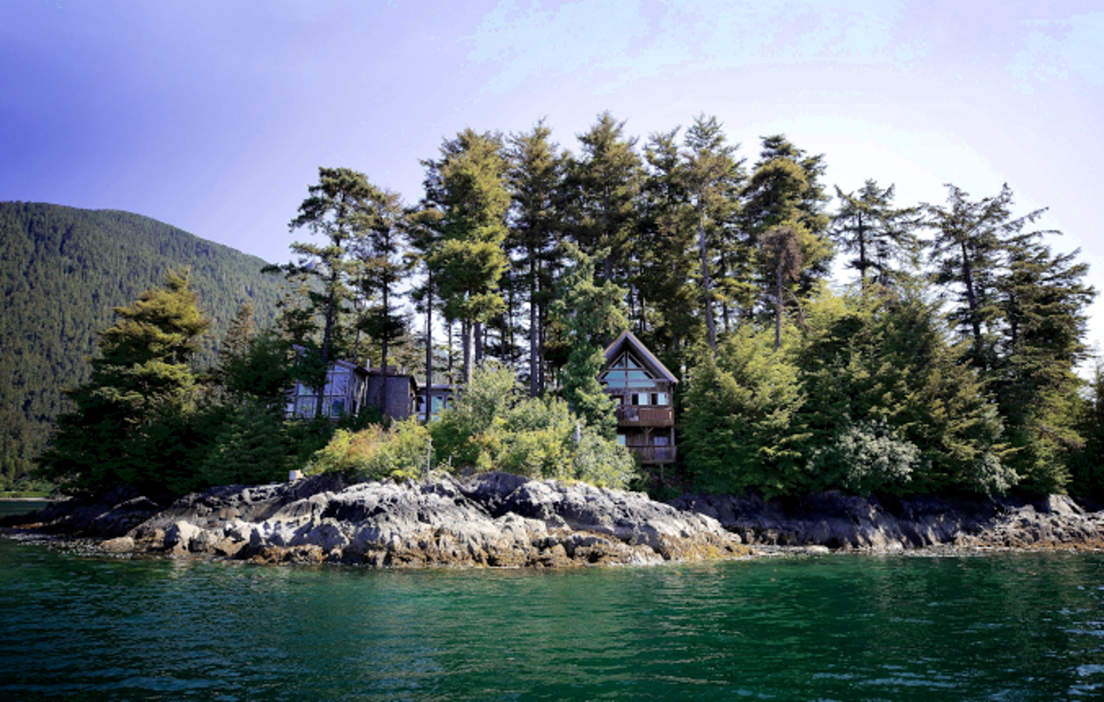 Cabin by water under blue skies in Alaska