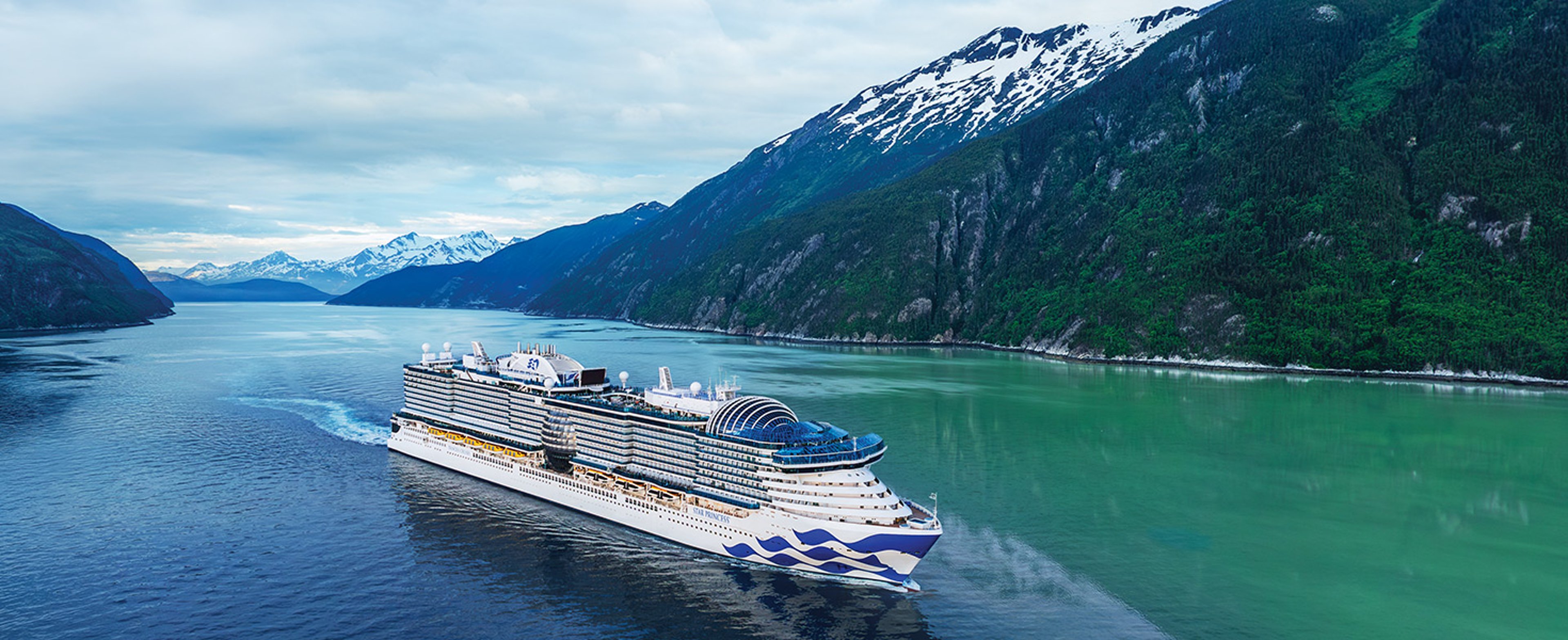 Princess Star sailing through waters along Alaska shoreline.