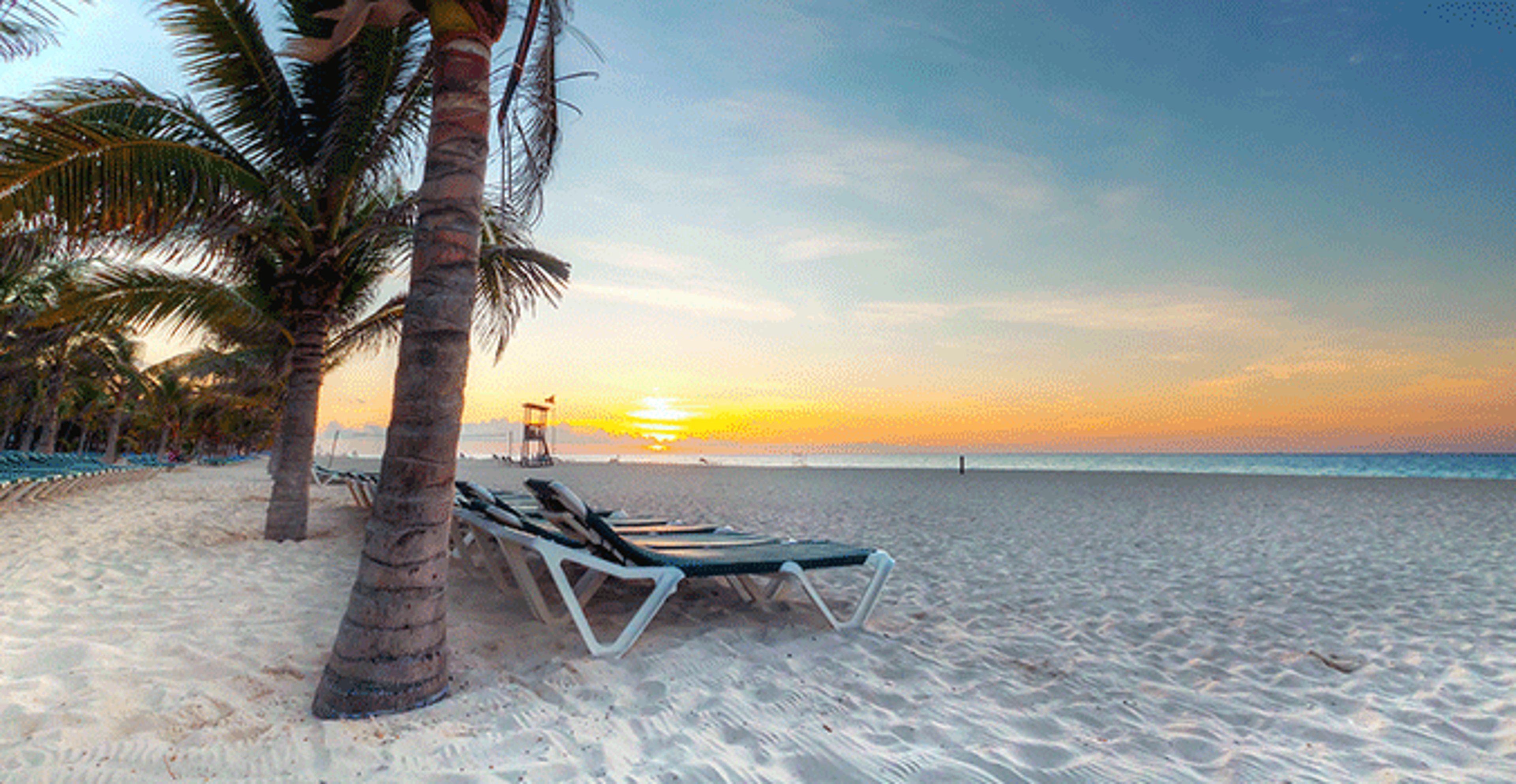 Beach chair on beach with sunset in background