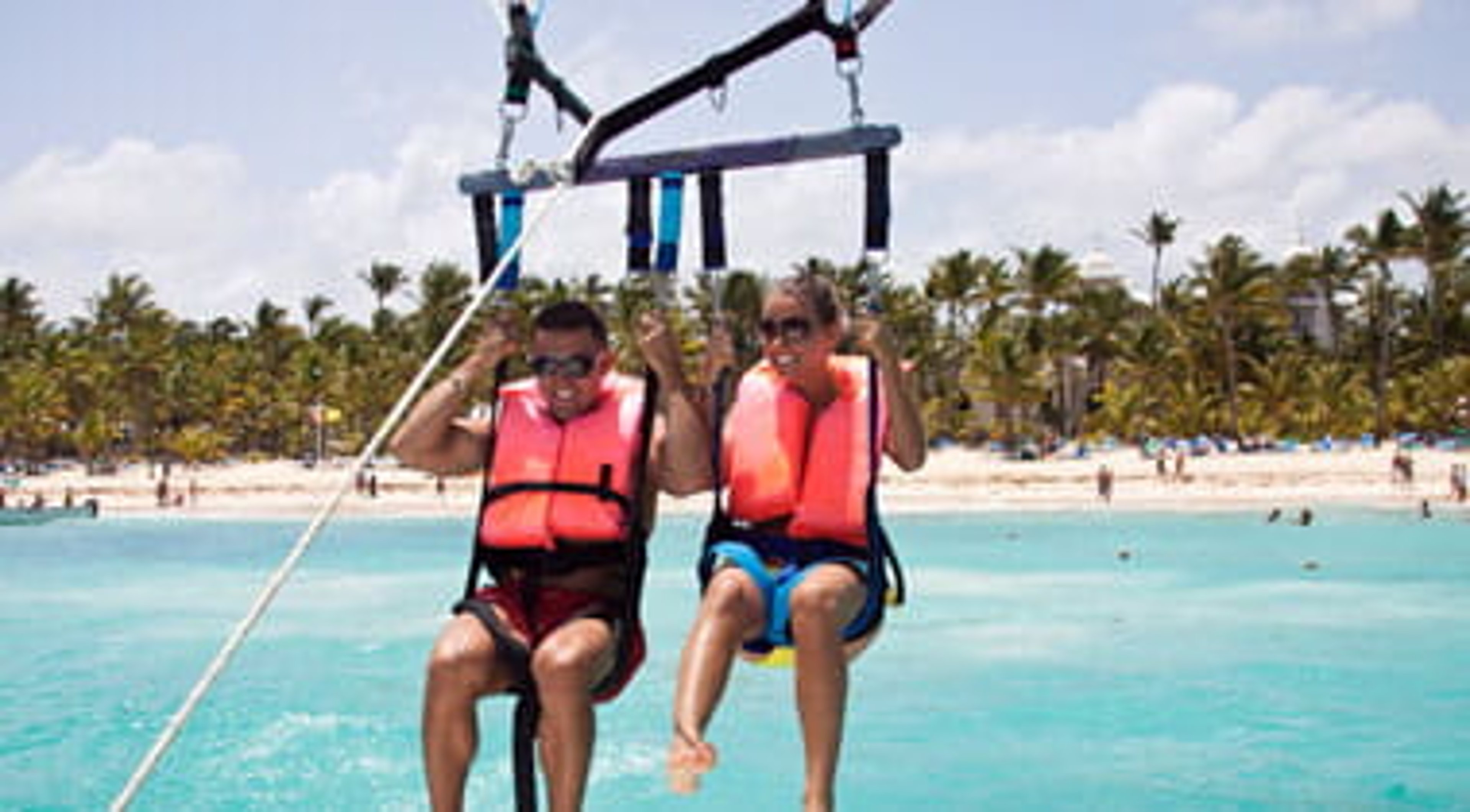 Parasailing excursion with a seated couple over a Dominican Republic beach