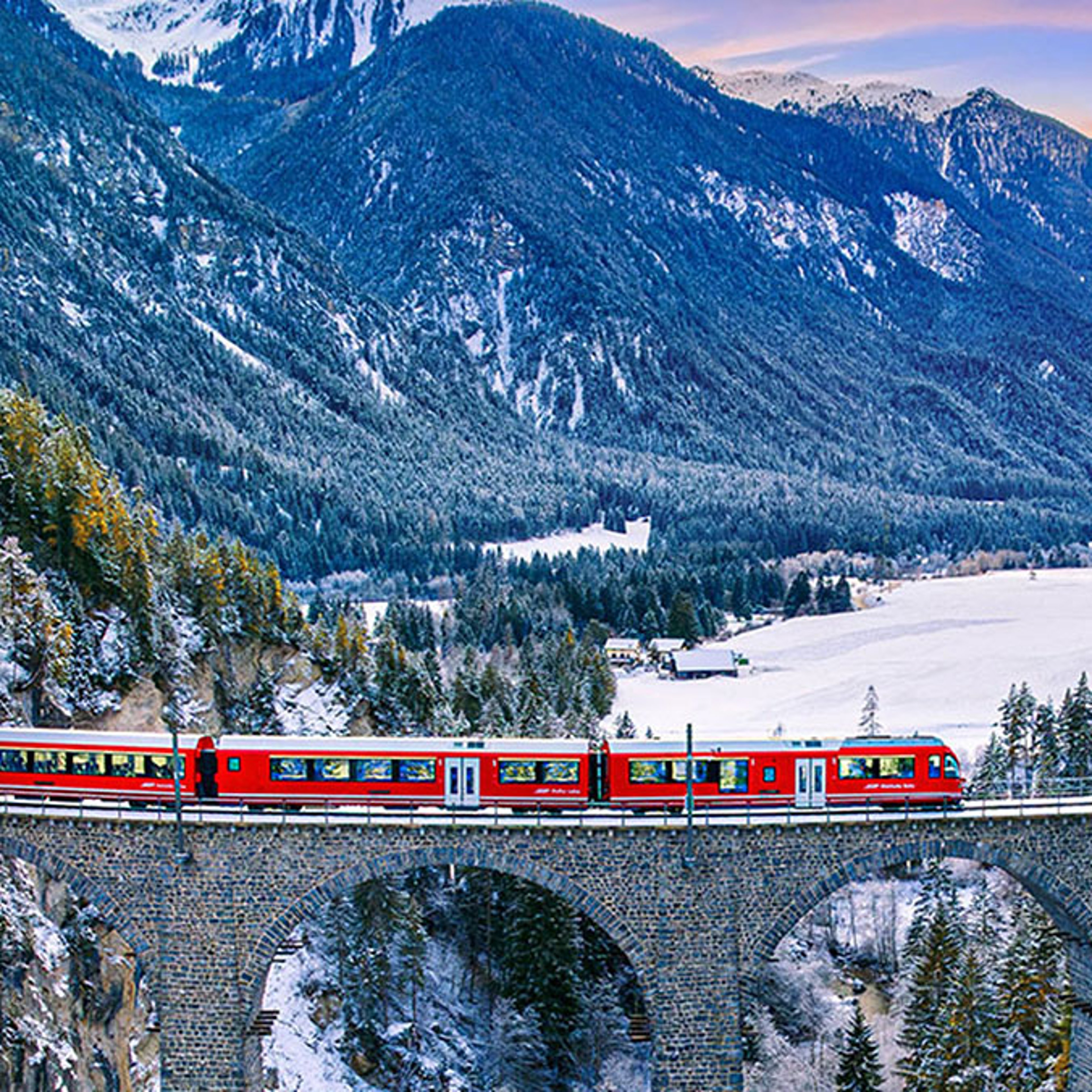 A red train over the scenic Landwasser Viaduct in Switzerland.