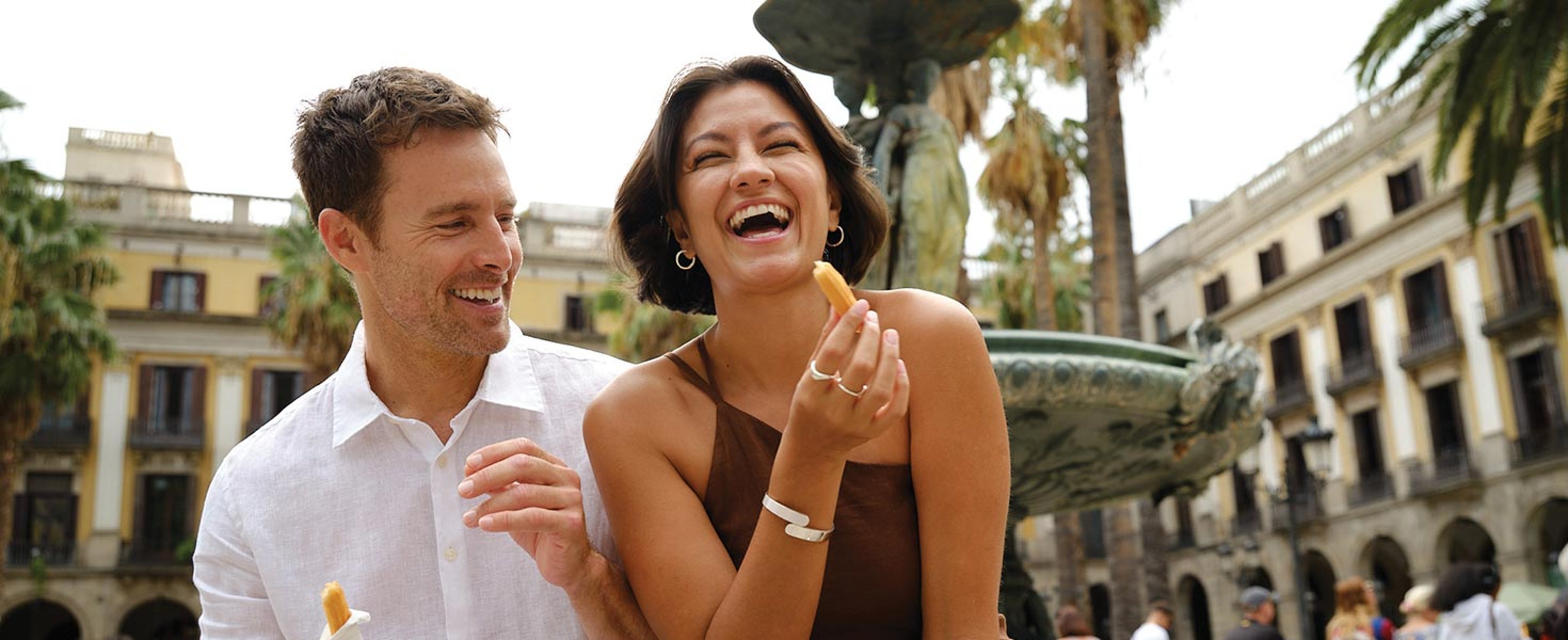 Couple eating and laughing while in Barcelona