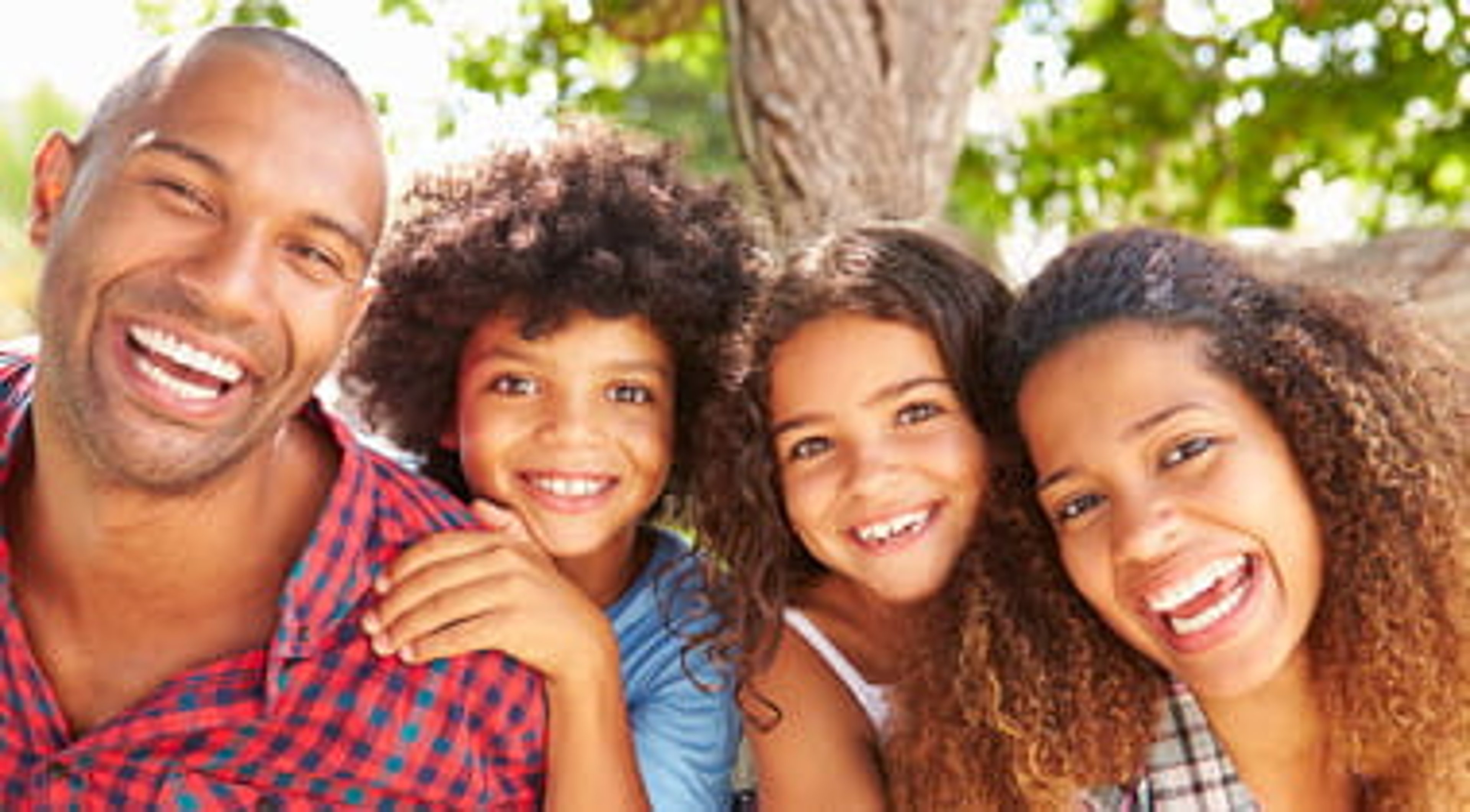 Family of Four Smiling Outdoors