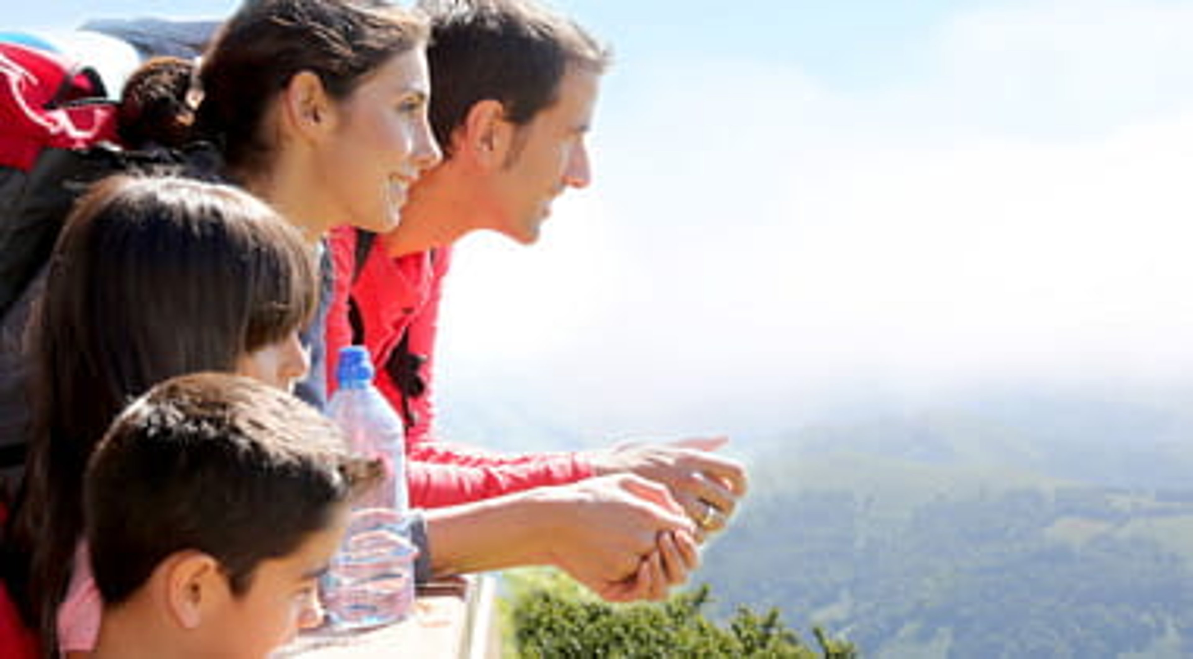 Family backpackers at the mountain looking at the valley view