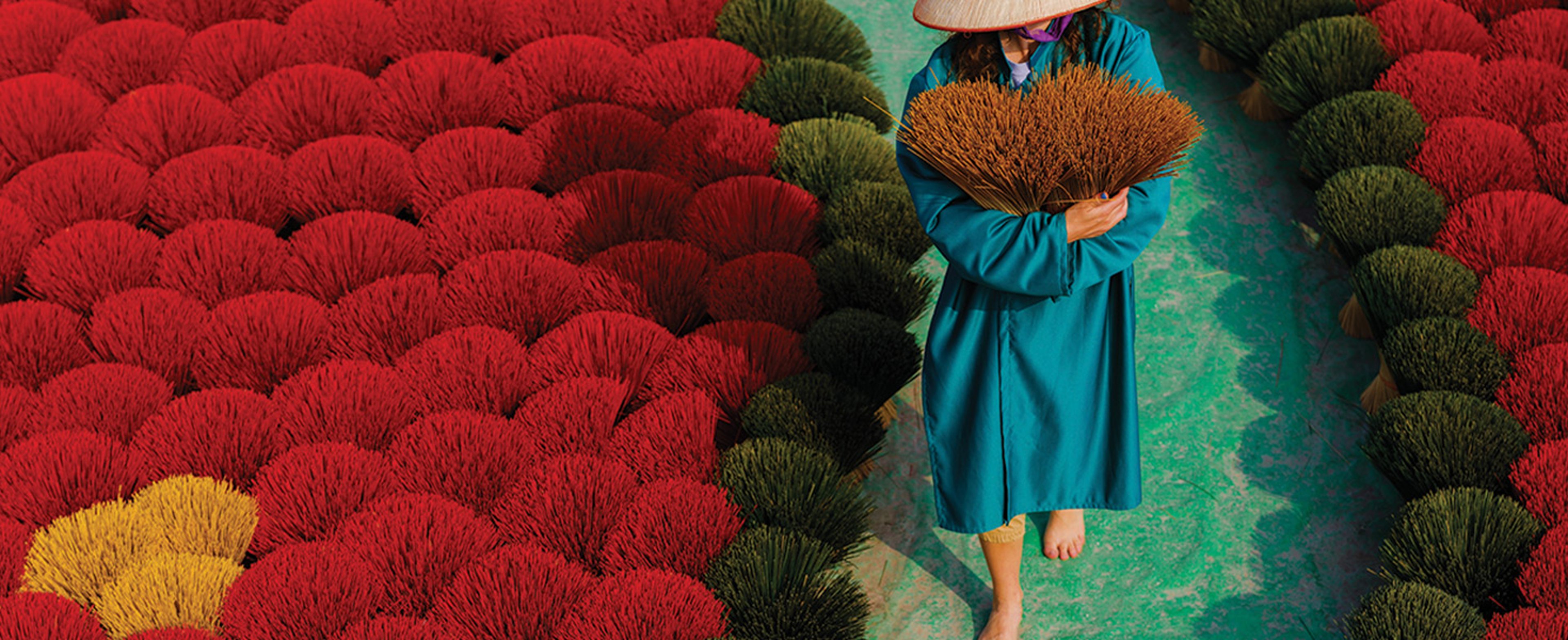 Woman in a straw hat walking down a path in Hanoi vietnam
