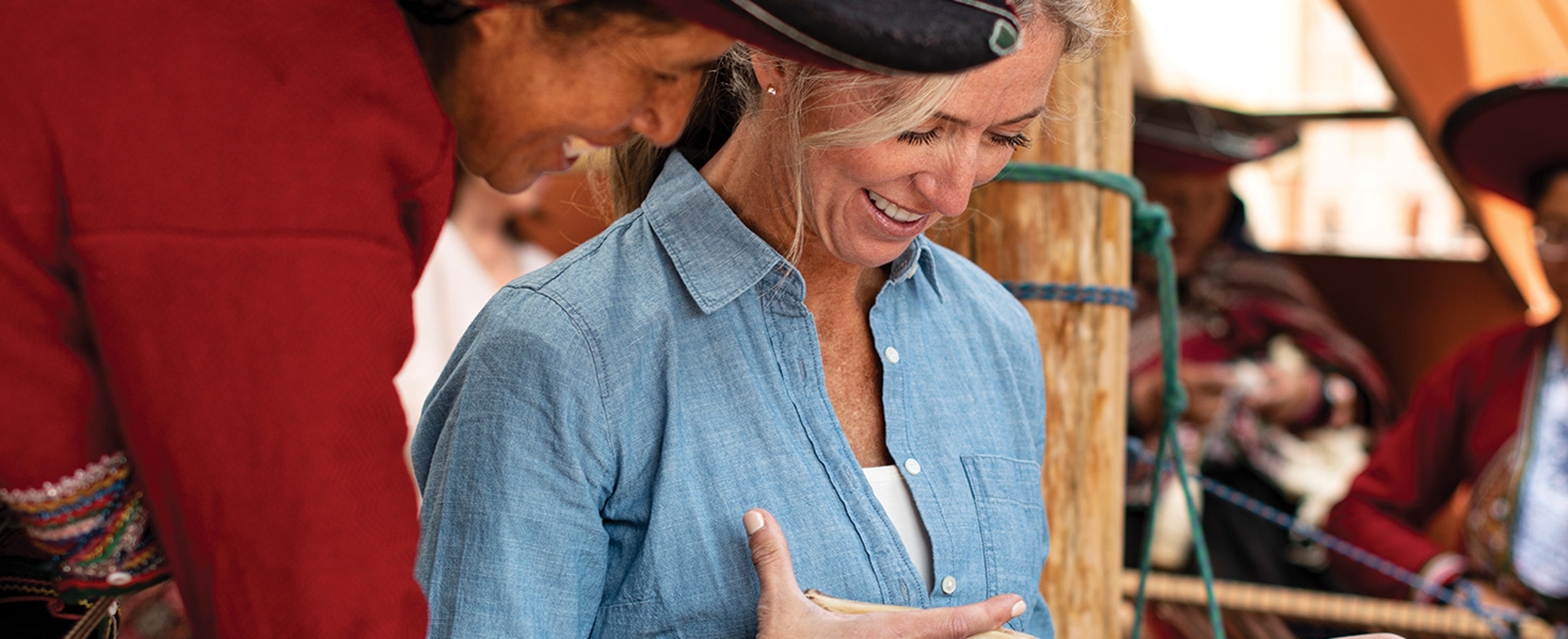 Weaver teaching a woman the skill at the Center for Traditional Textiles of Cusco