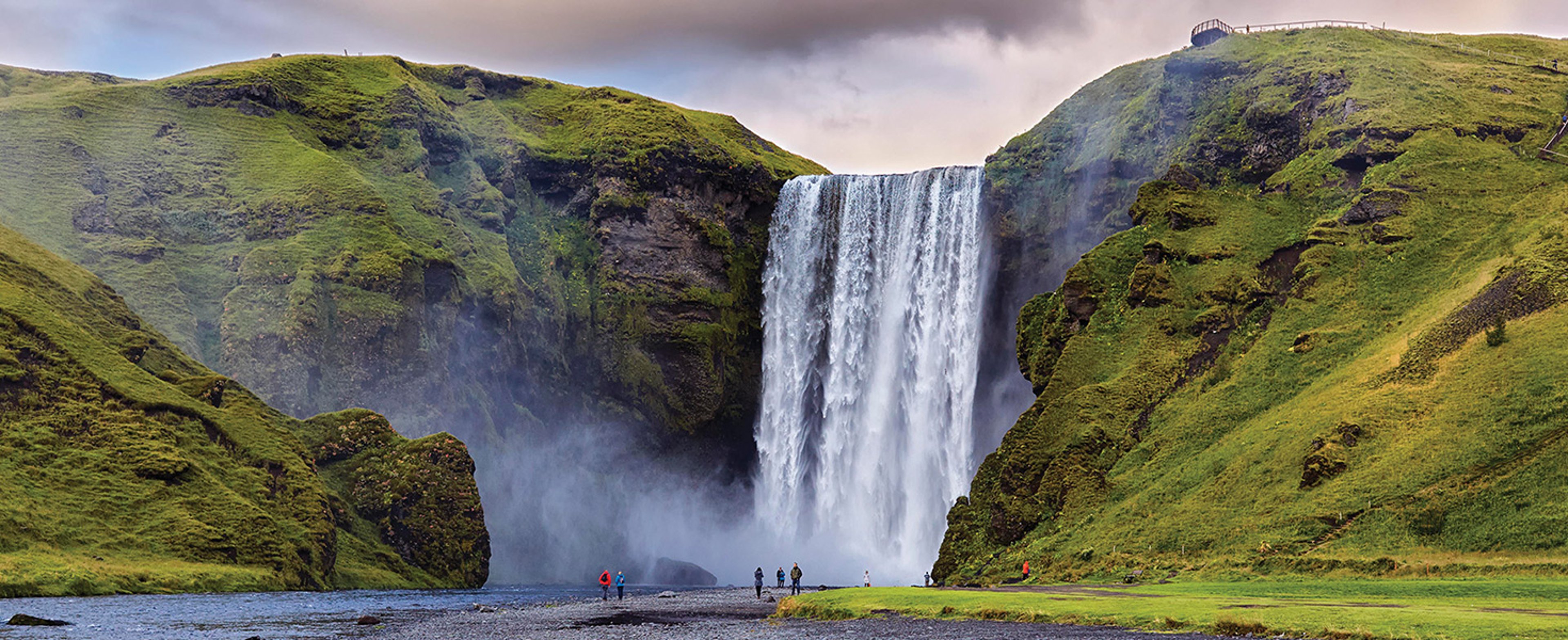 Visitors standing at the bottom of the Skogafoss Waterfall, Iceland