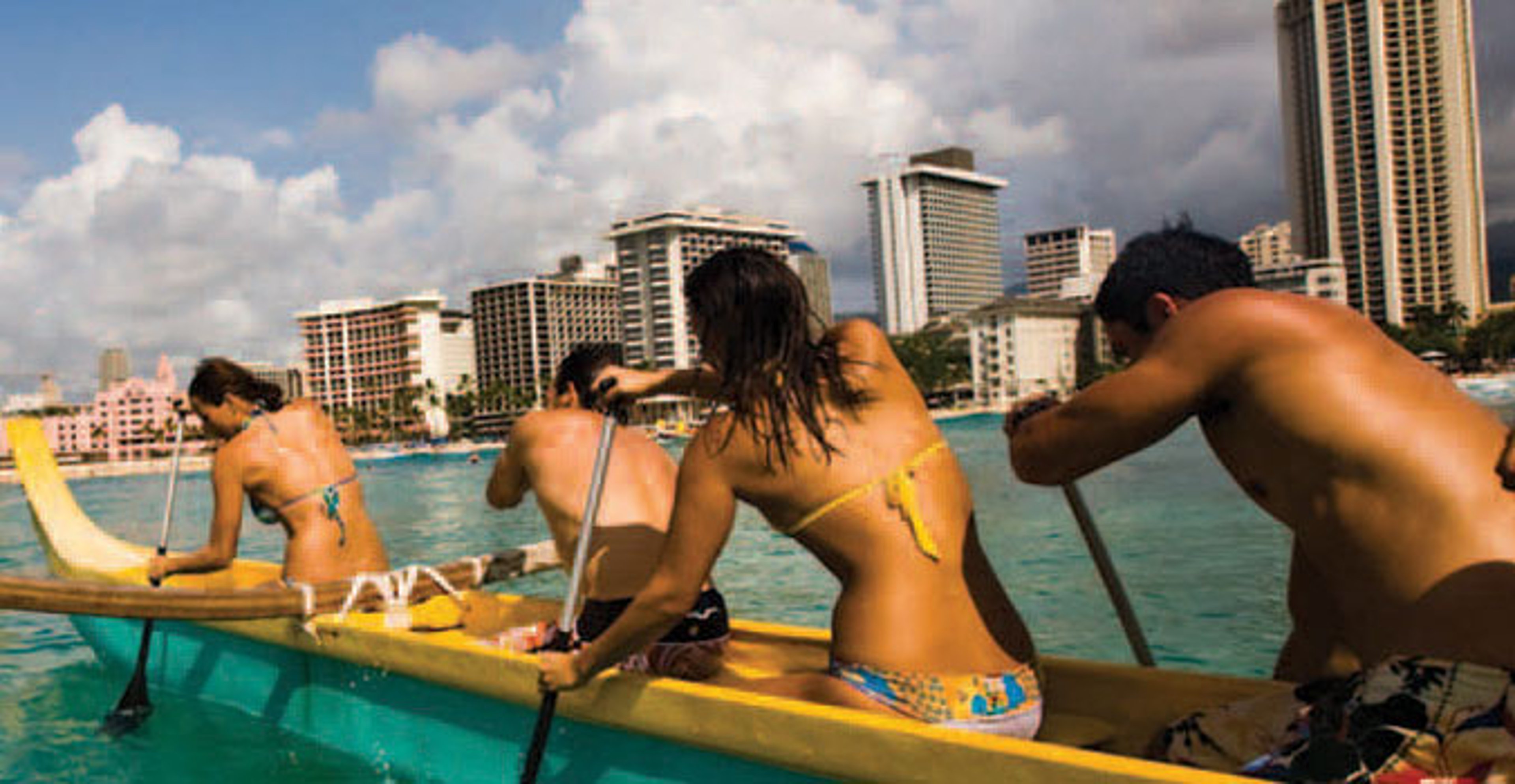 Men and Woman paddling on a boat in the Ocean