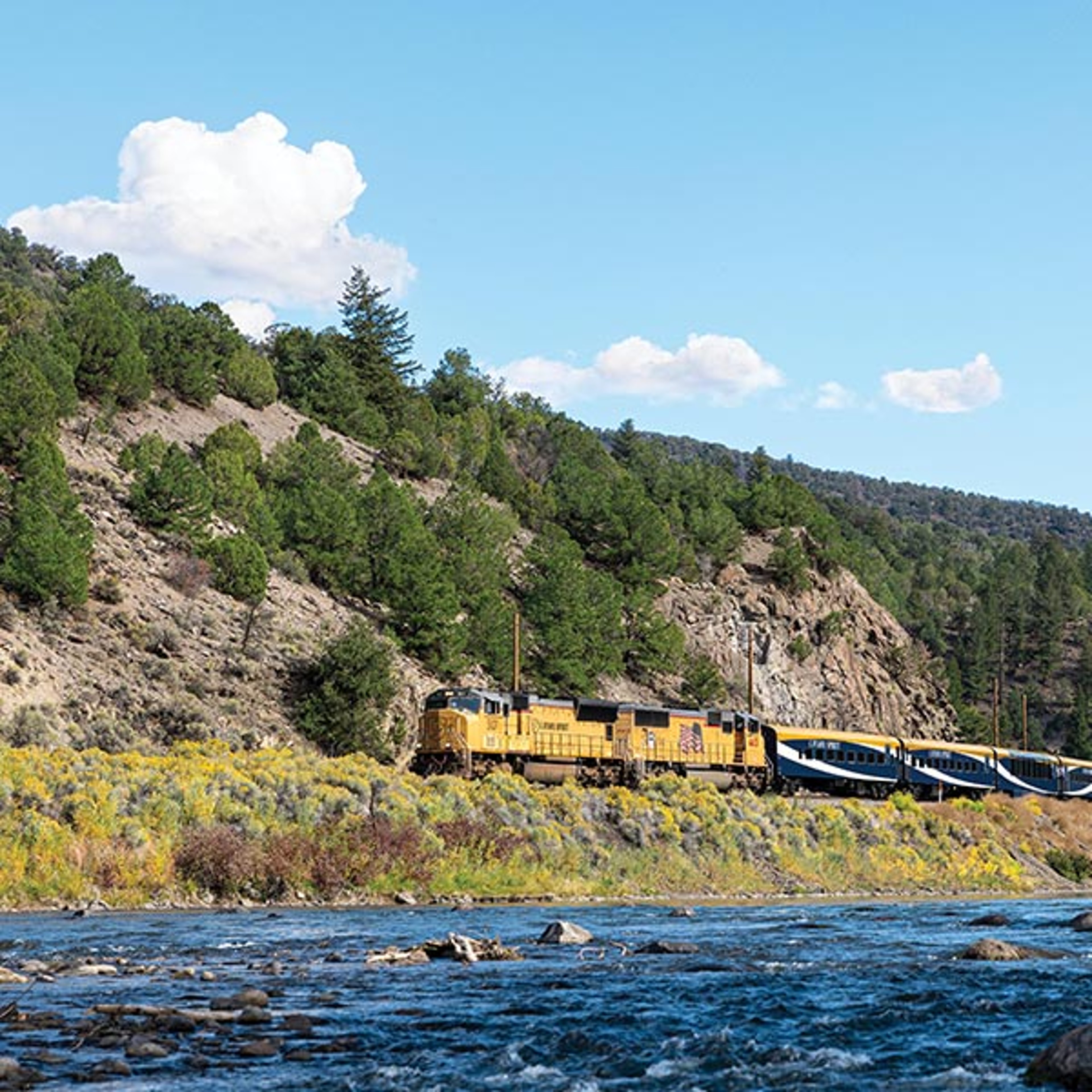 Canyon Spirit train traveling along the water in Grizzly Creek