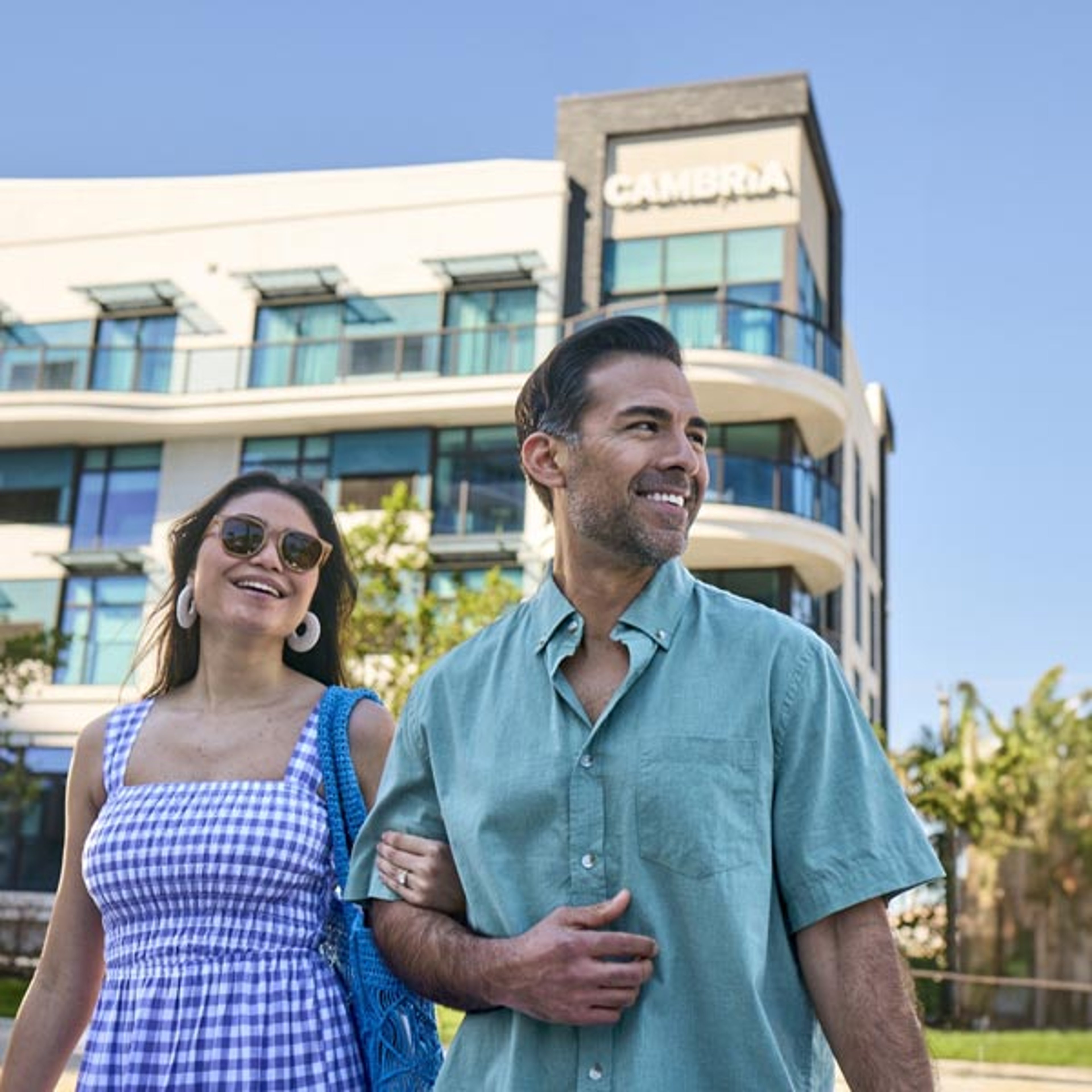Couple walking arm in arm in front of a Choice hotel
