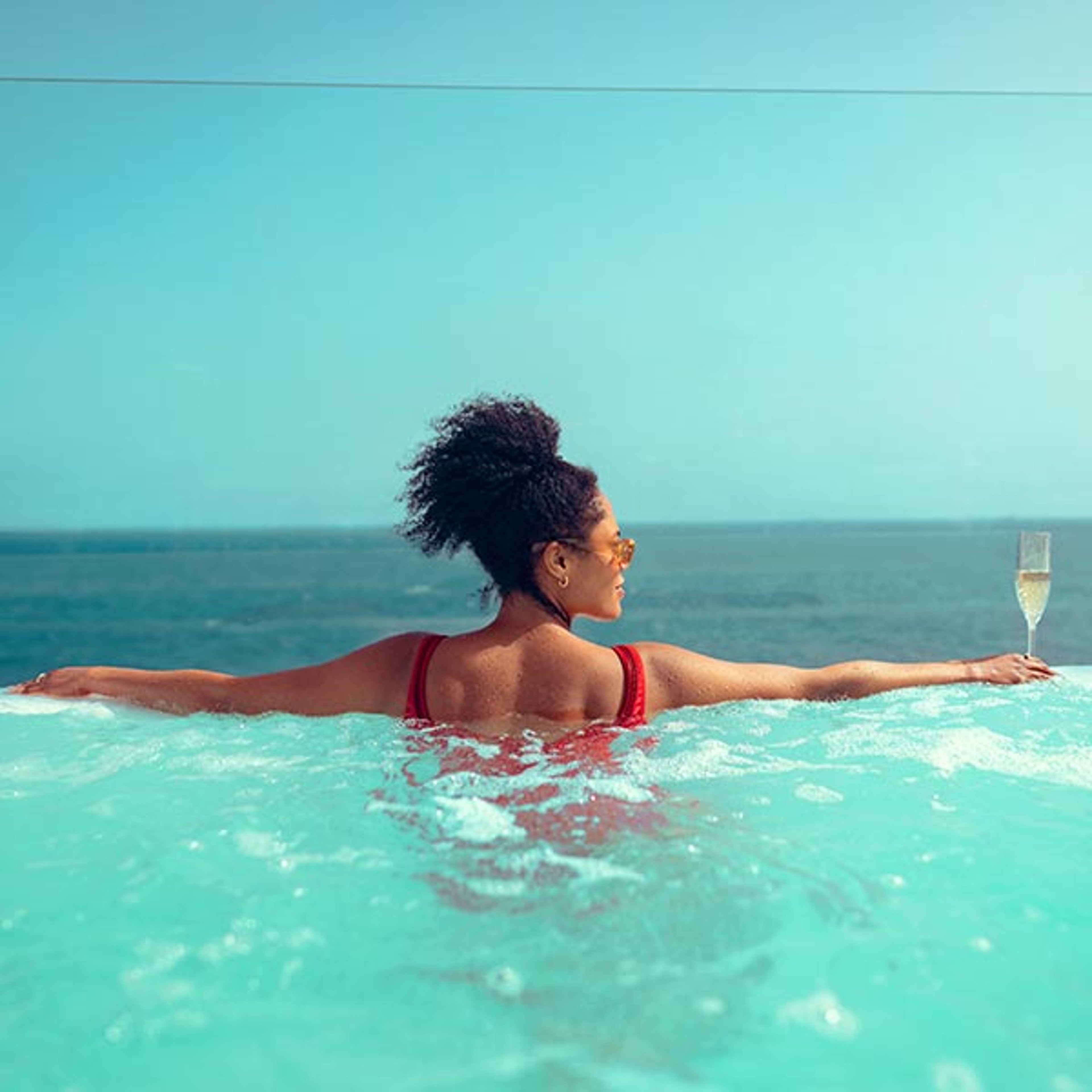Woman standing at edge of Cunard ship pool overlooking the ocean