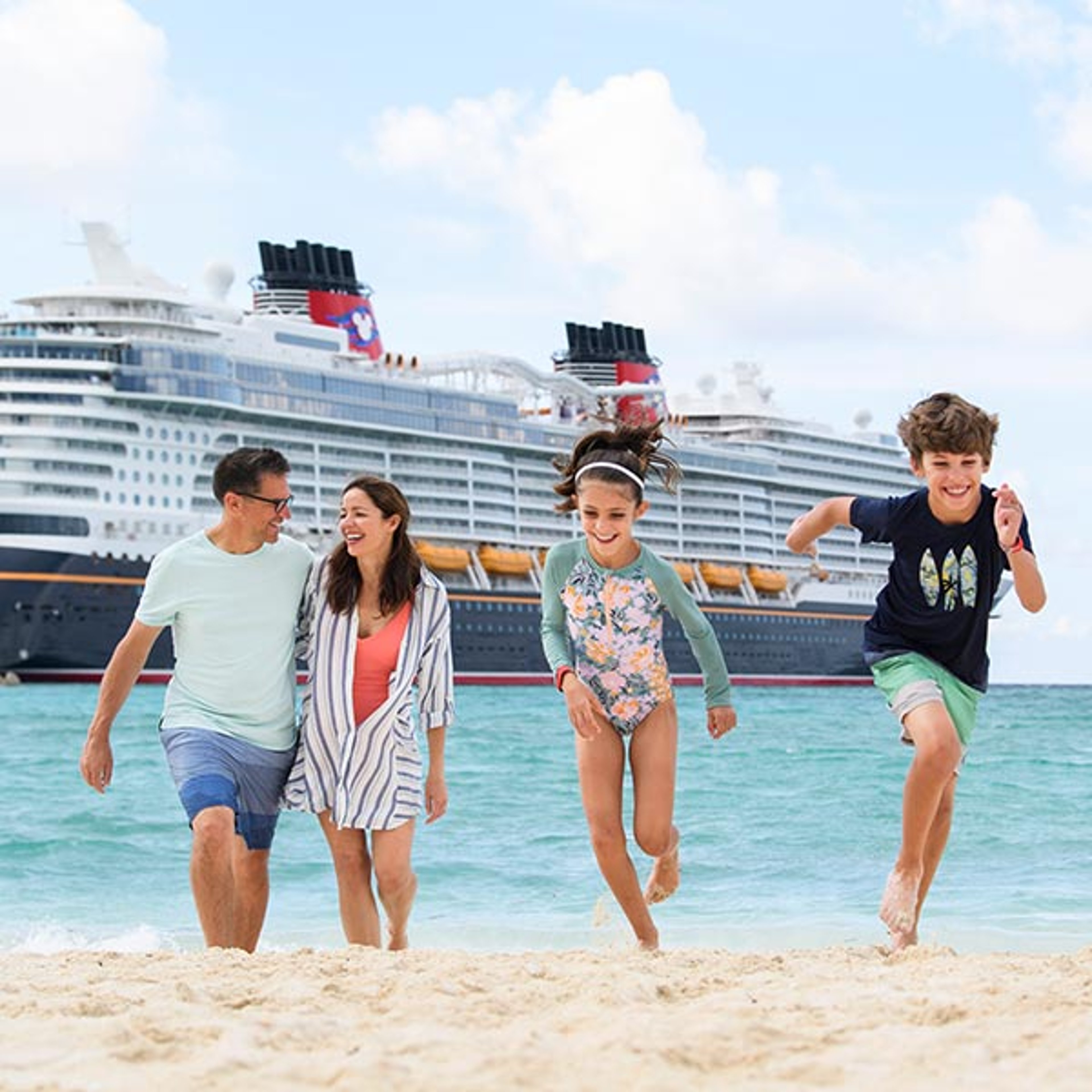 Family on beach with Disney Cruise ship in background