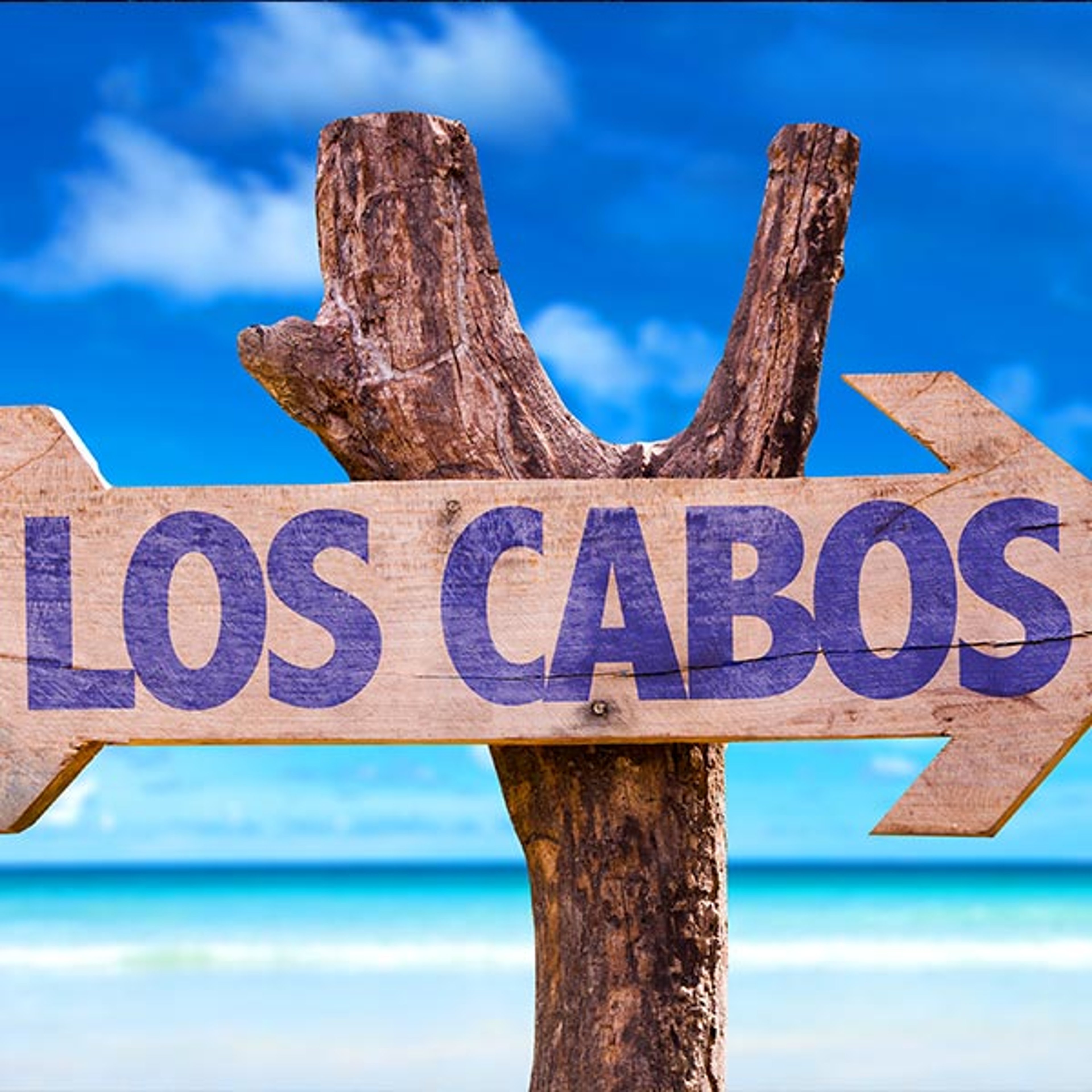 Sign on the beach pointing the way to Los Cabos, Mexico