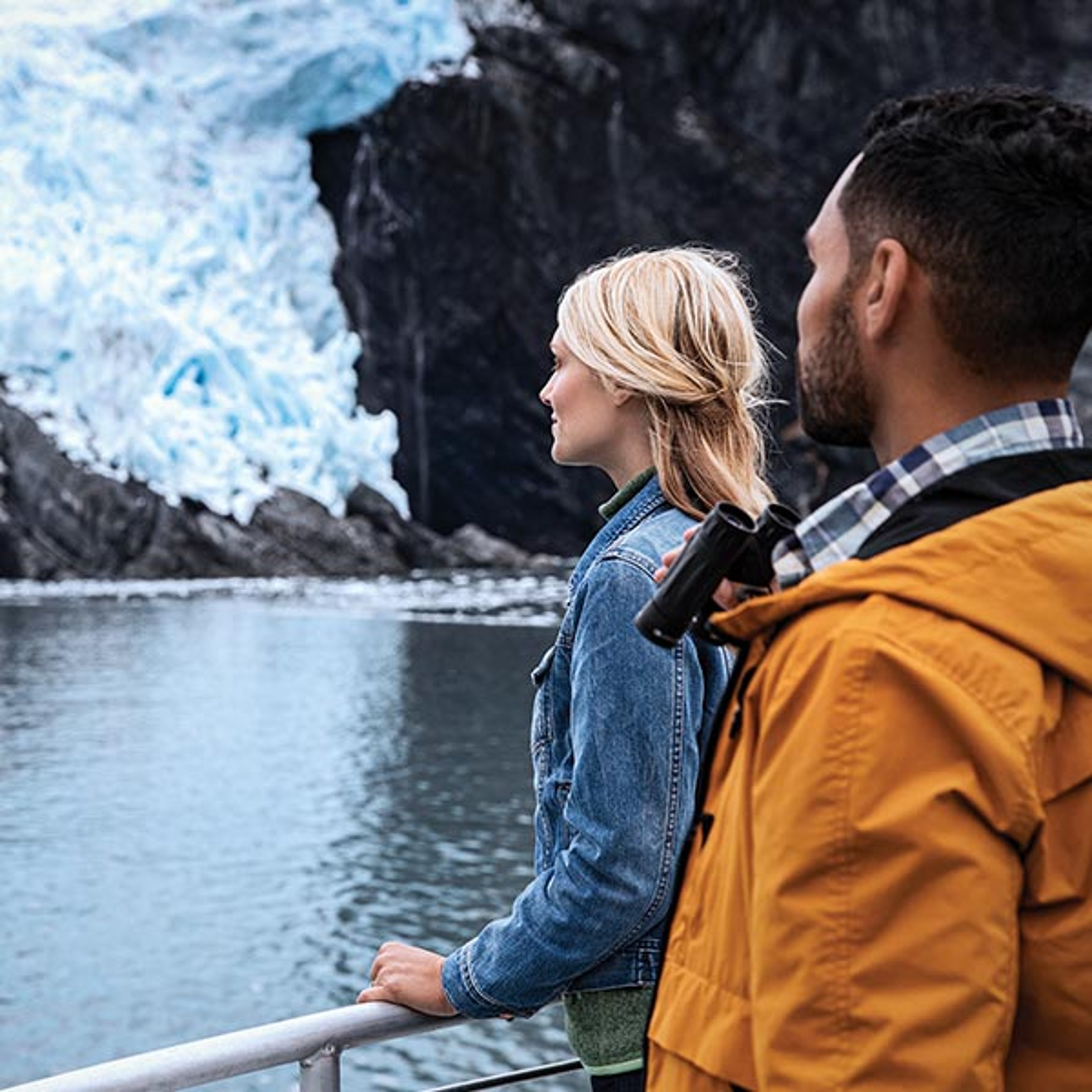 Couple standing at deck rail on a Princess ship cruising through Alaska
