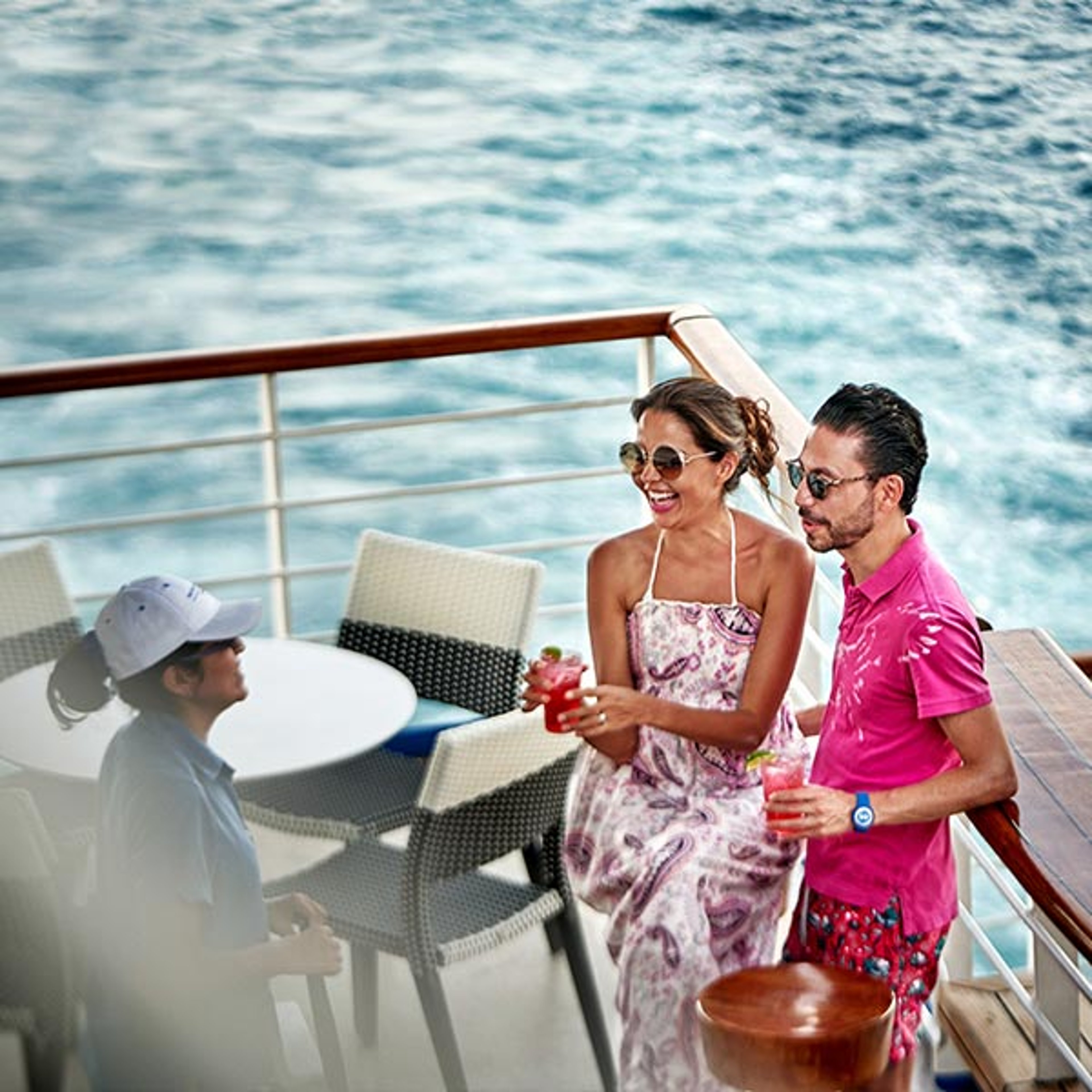A couple enjoying drinks on the deck while cruising with Princess