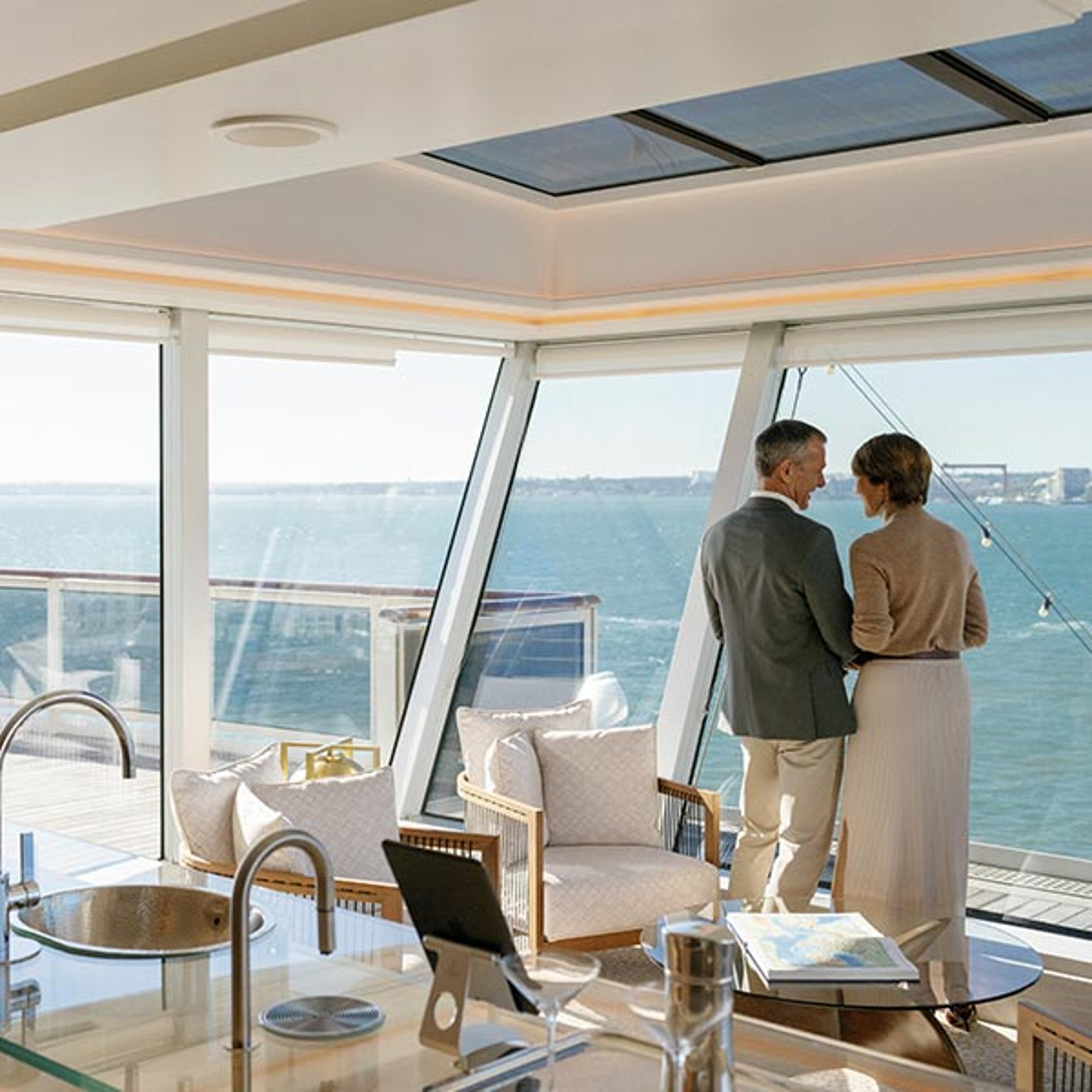 Couple looking out window at scenery while sailing with Regent
