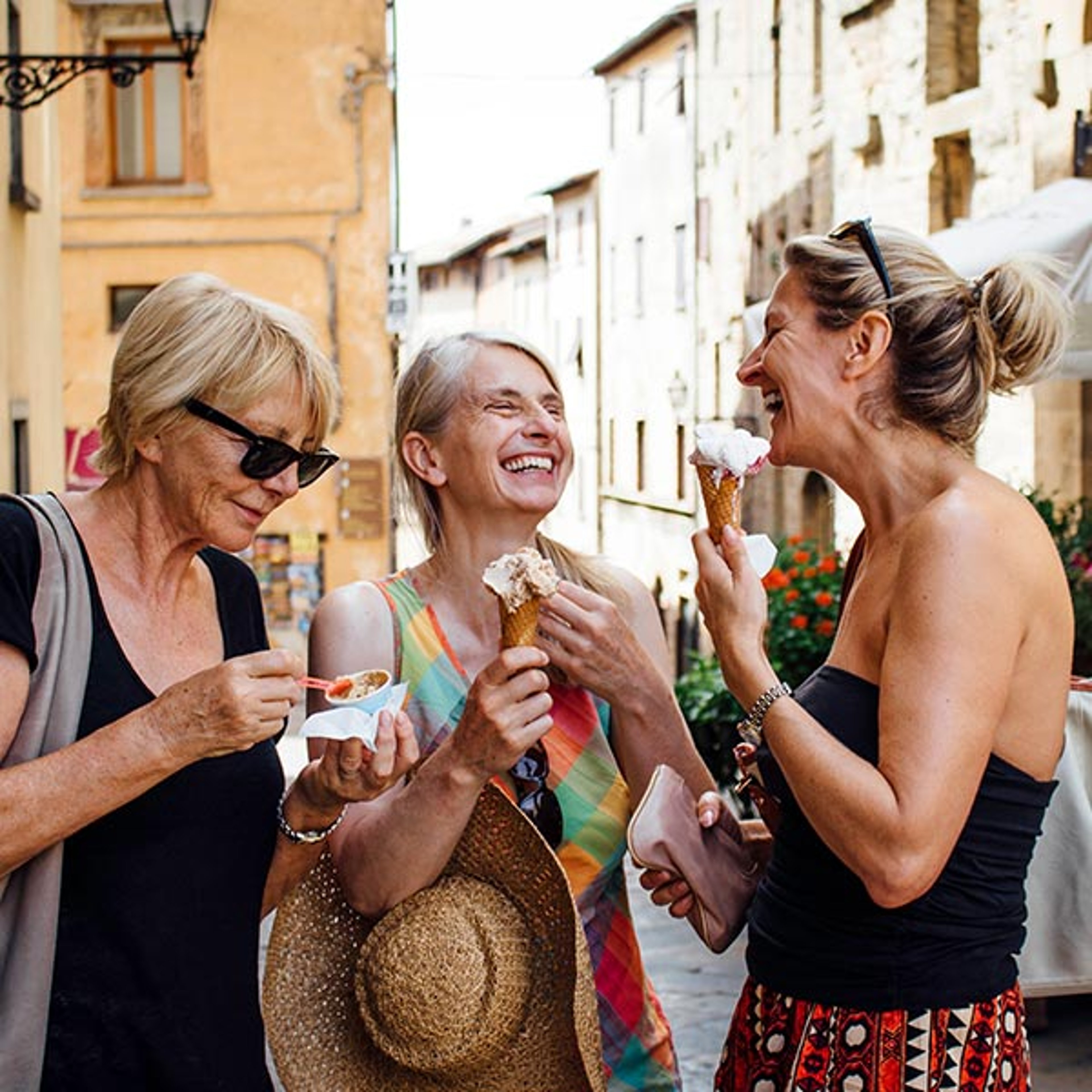 Three girlfriends eating ice cream while on guided tour
