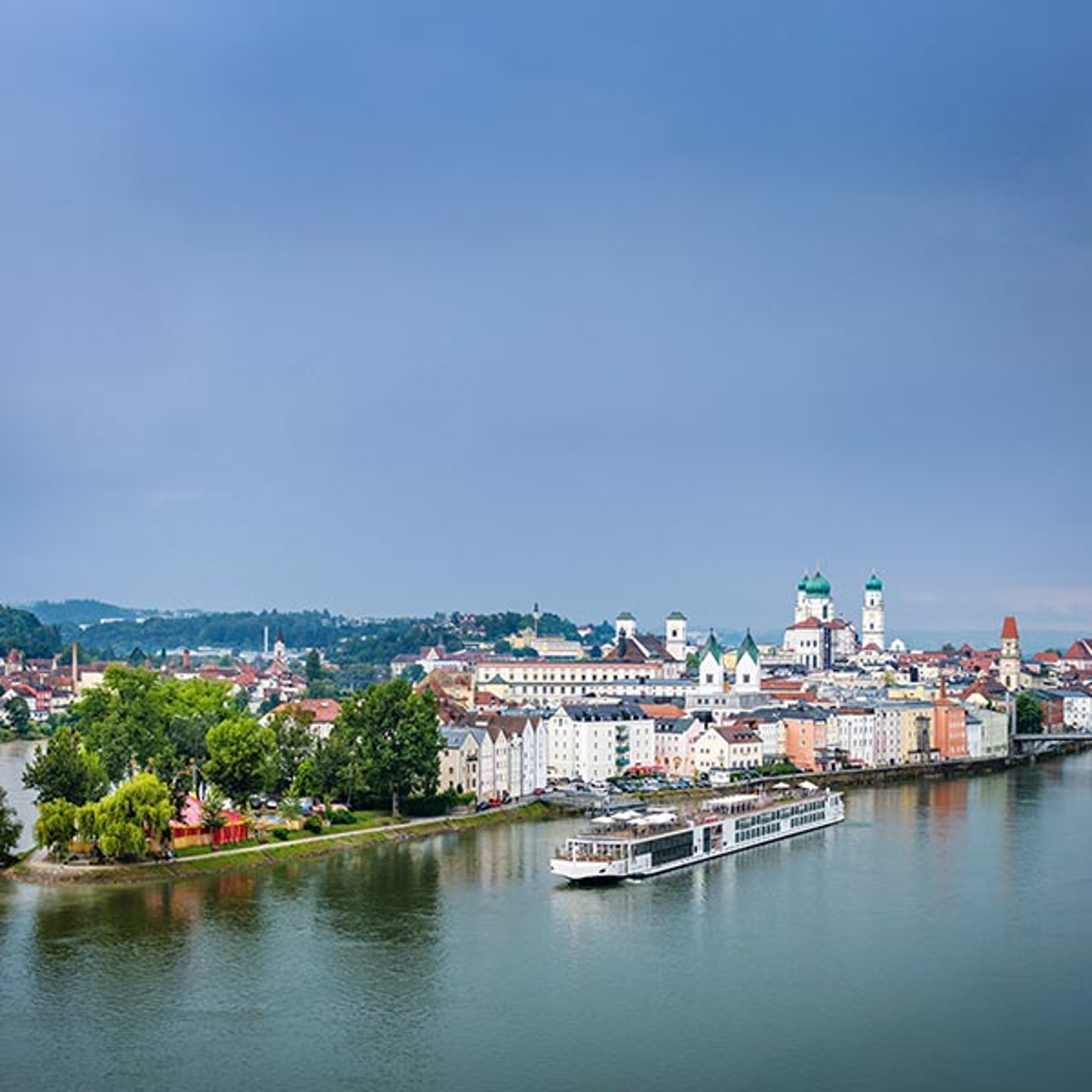 The image shows a Viking longship in front of the historic waterfront of Passau, Germany, a Bavarian city situated along the Danube River