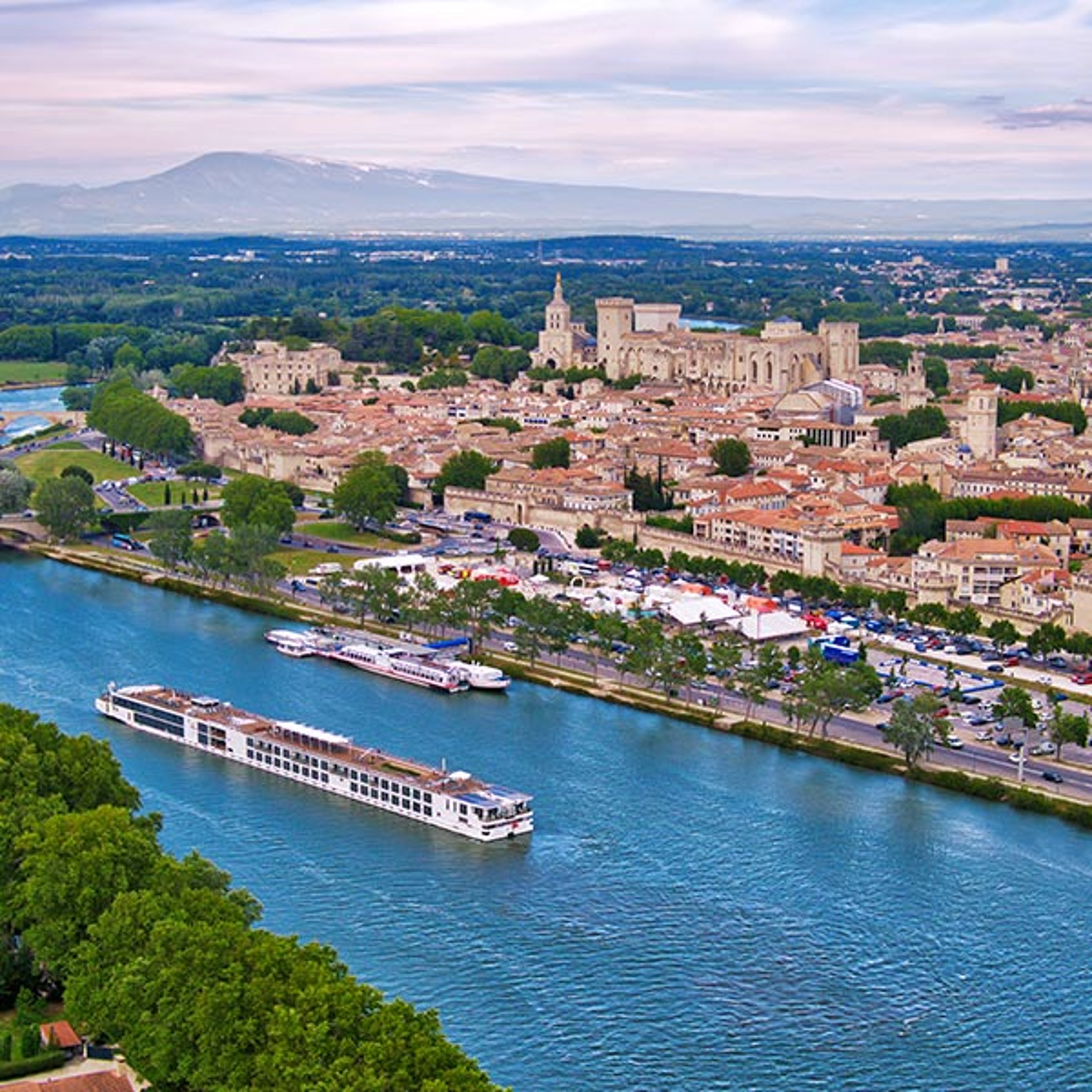 The image appears to show an aerial view of Avignon, France, along the Rhône River with a Viking Longship cruising by.