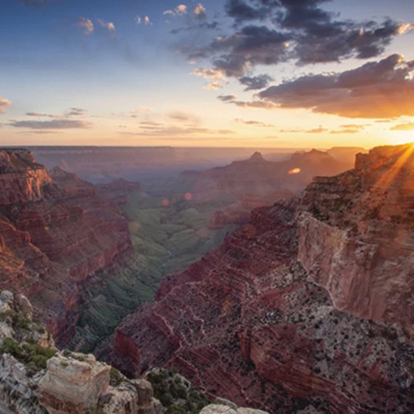 Grand Canyon at sunset with sunlight over the layered canyon walls.