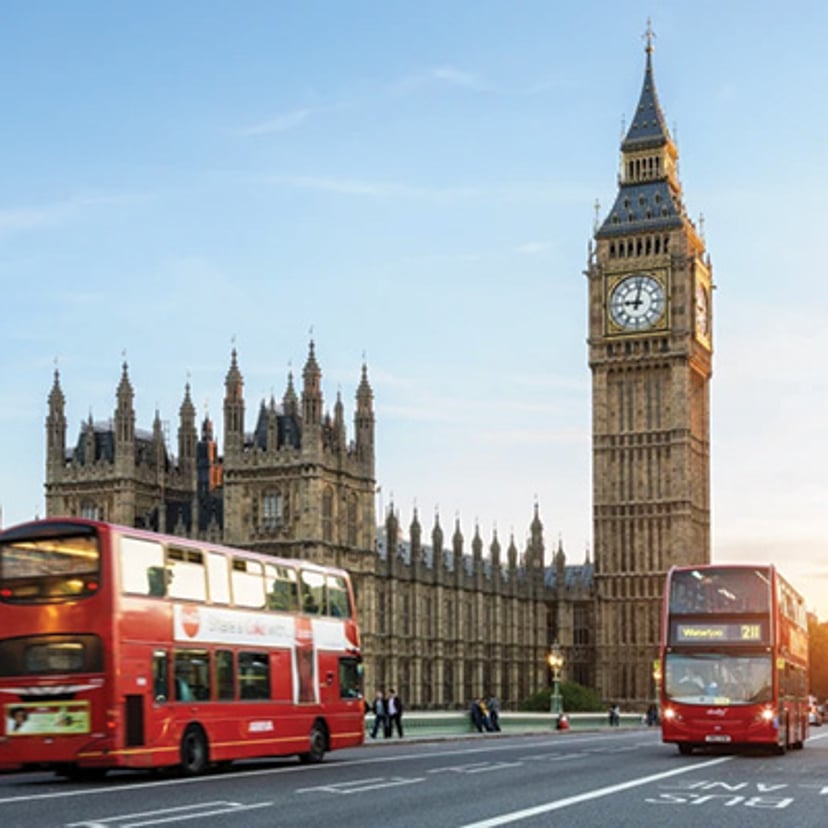 Big Ben and the Houses of Parliament with red double-decker buses in London.